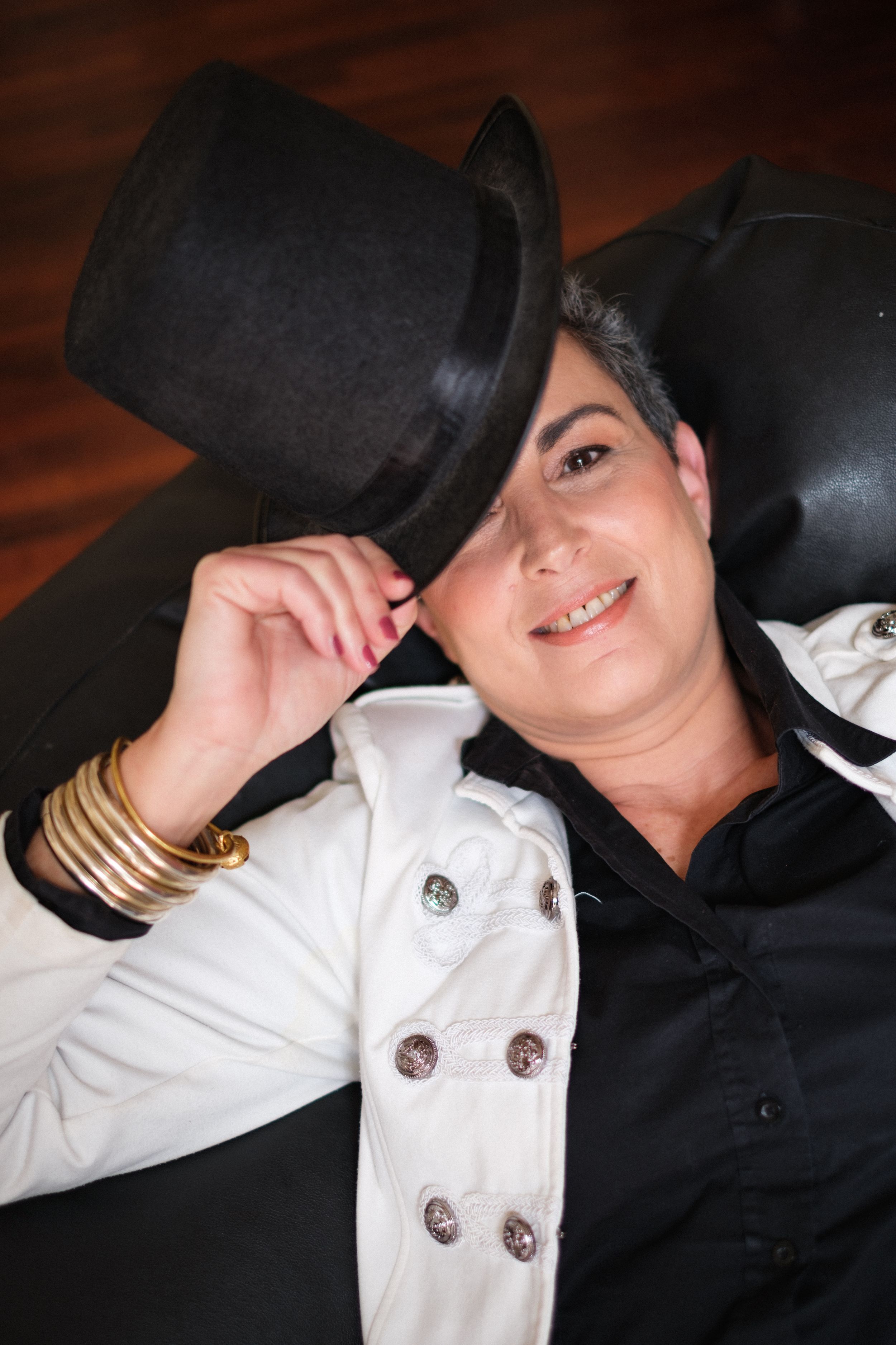 Playful sequence with someone wearing a black hat and white button-up shirt against dark background.