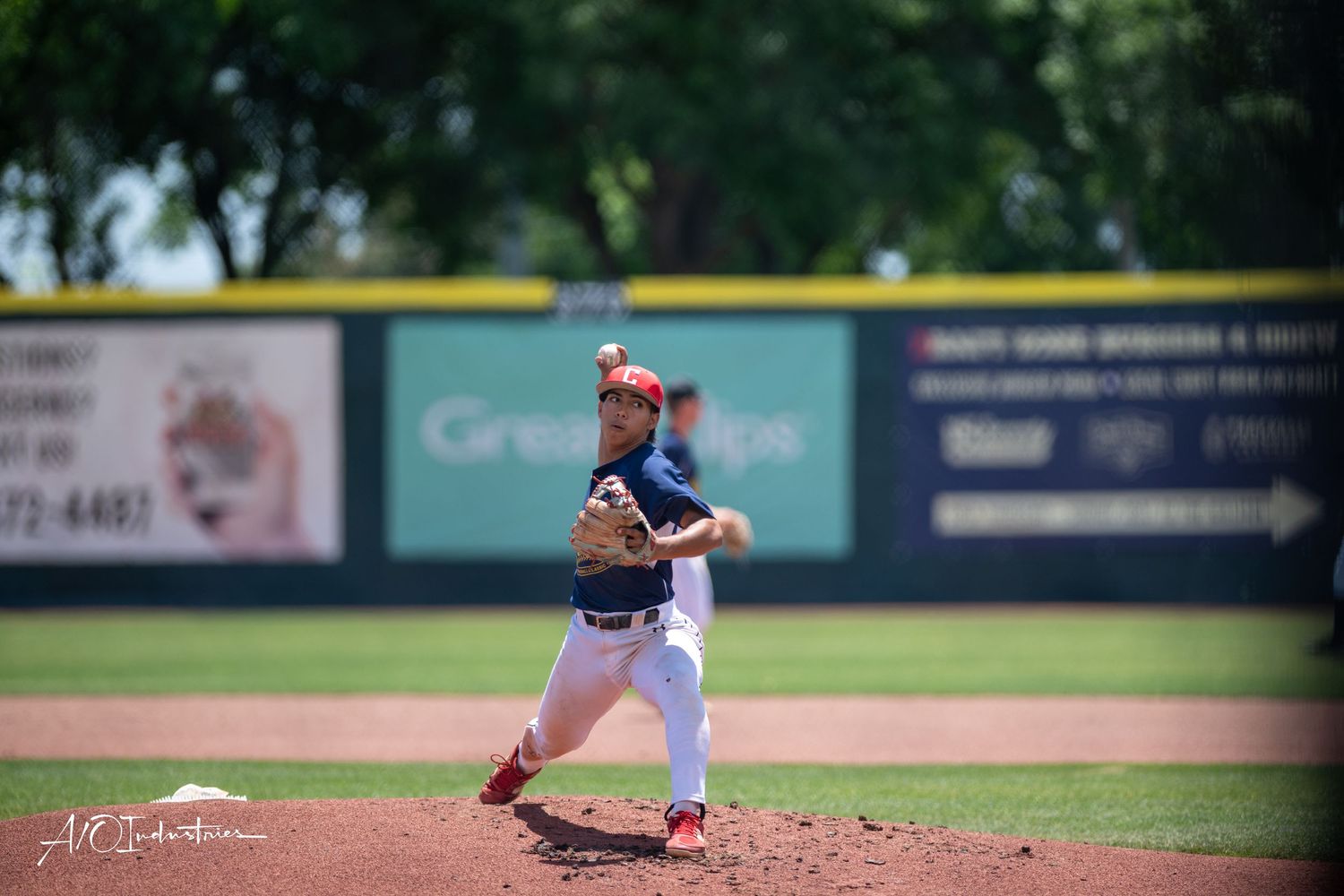 A baseball pitcher in a uniform stands on the mound during a game at a stadium.
