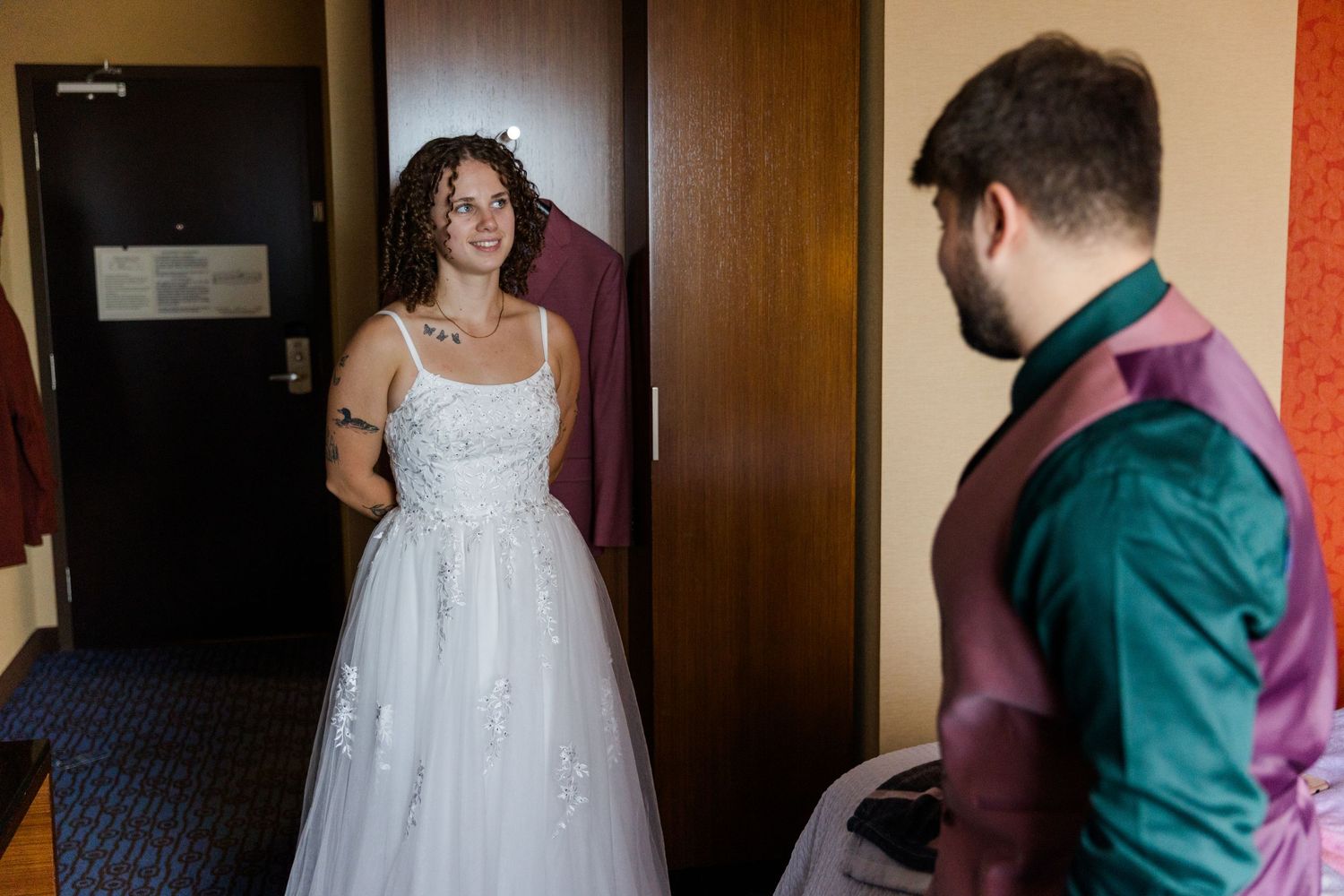 A wedding couple performs a traditional first dance in a room with wooden paneling and red decor.