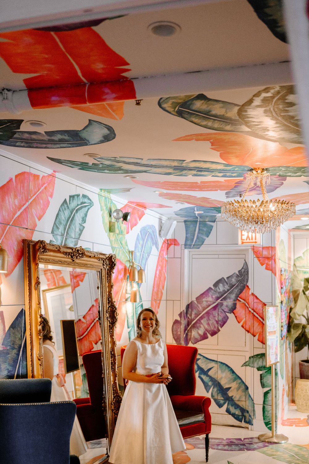 Whimsical event space decorated with colorful hanging butterflies and elegant crystal chandeliers.