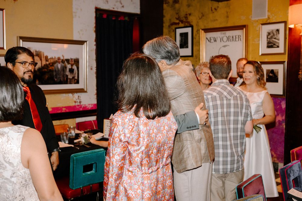 Party guests socialize and celebrate in a warmly lit space decorated with vintage photographs.