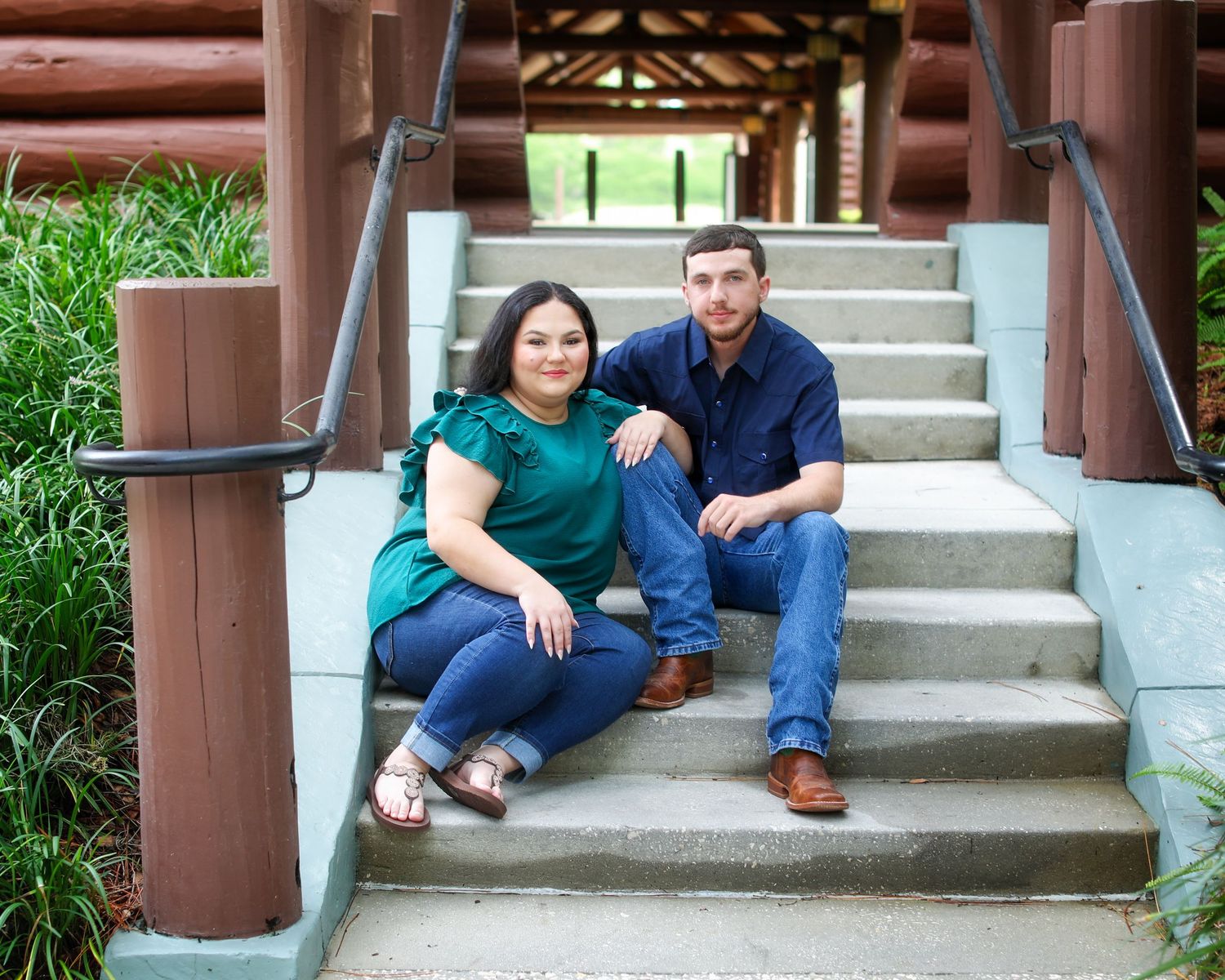 A couple sits casually together on outdoor concrete steps for a series of laid-back portrait photos.