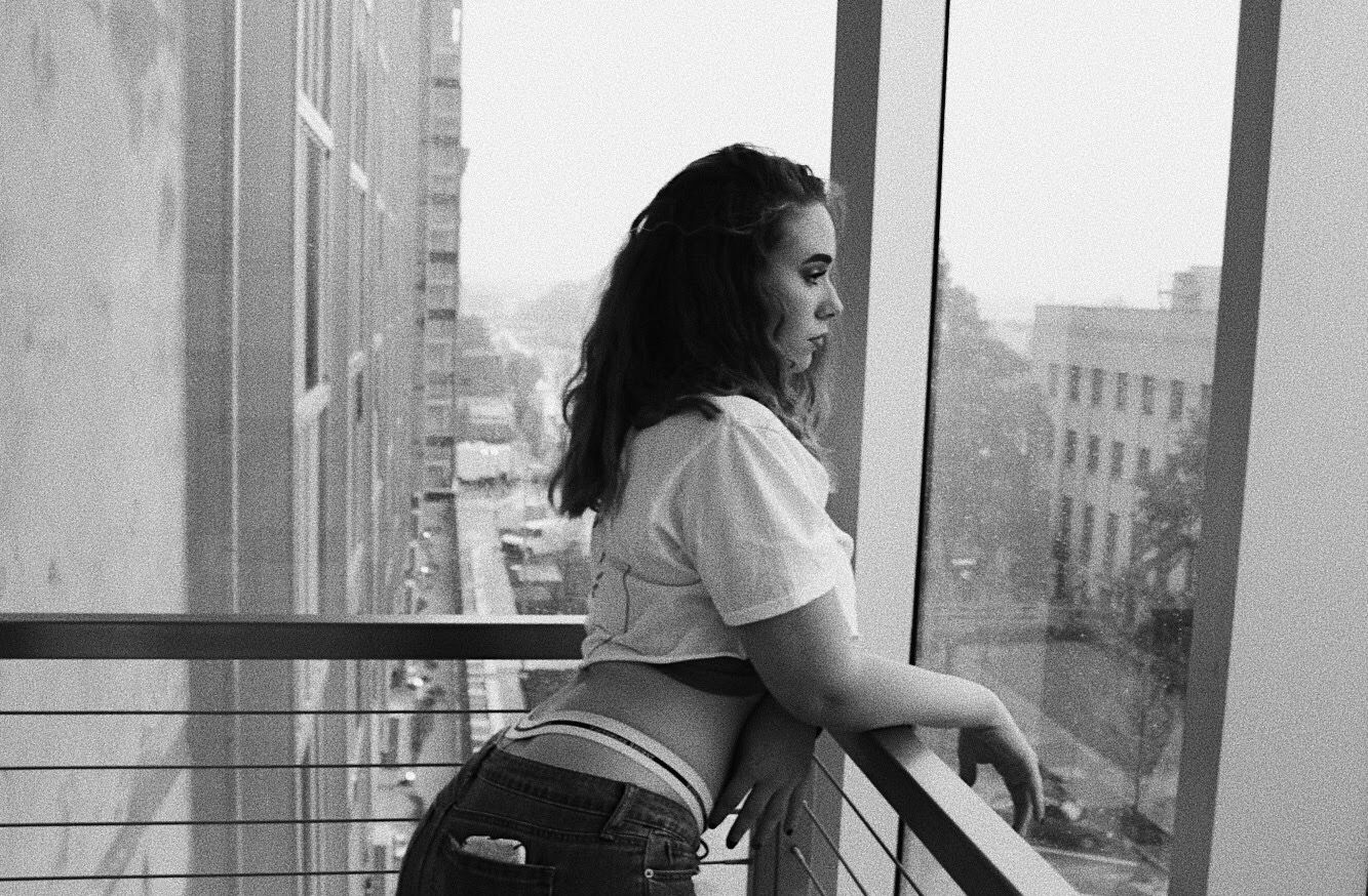 Woman Stares Into the Distance in Stairwell Located in Arts Parking Garage