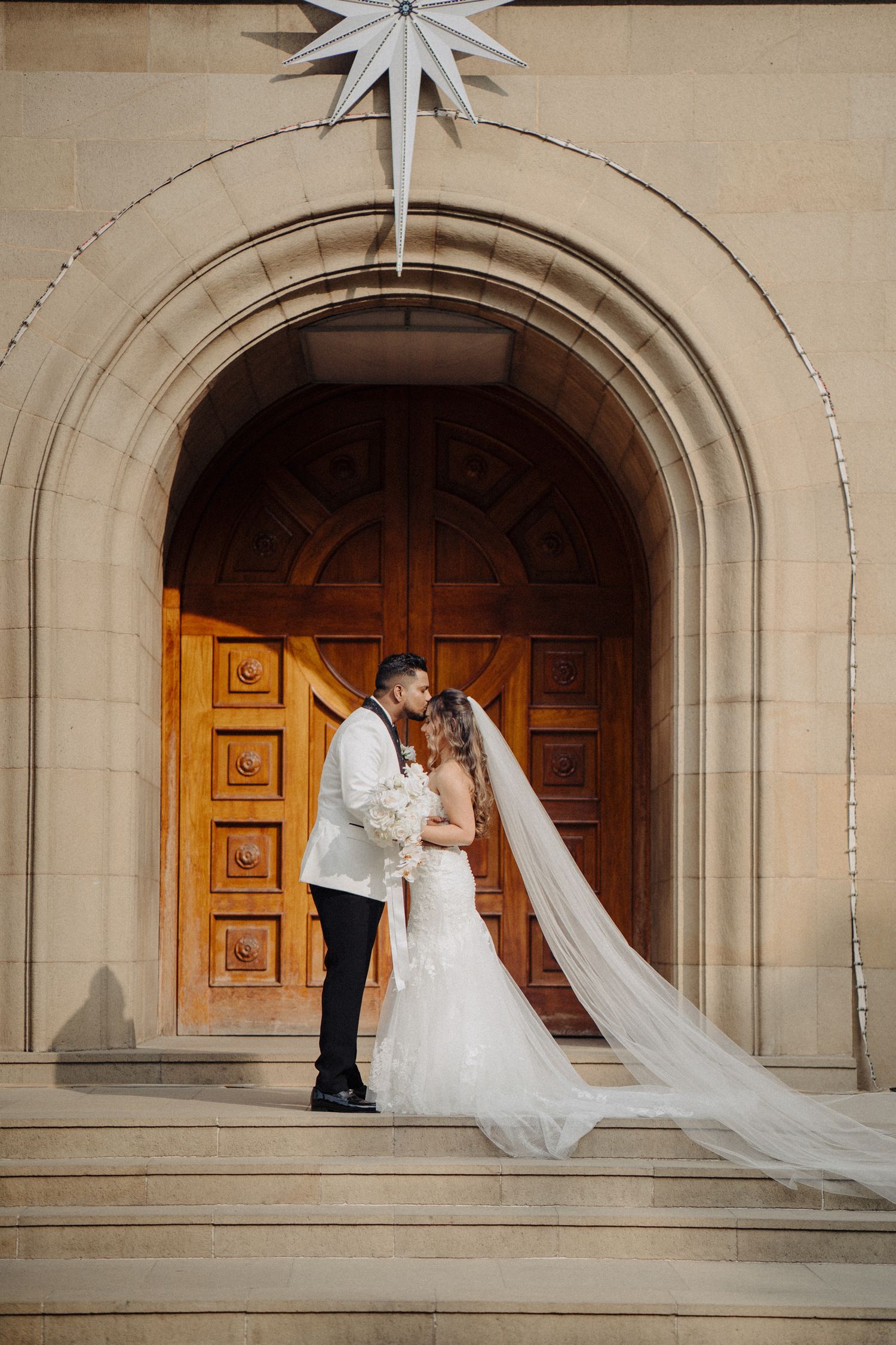 Thought for 0sWedding photo sequence under stone archways with flowing white veil & dress by a wedding photographer in Sydney, Gold Coast