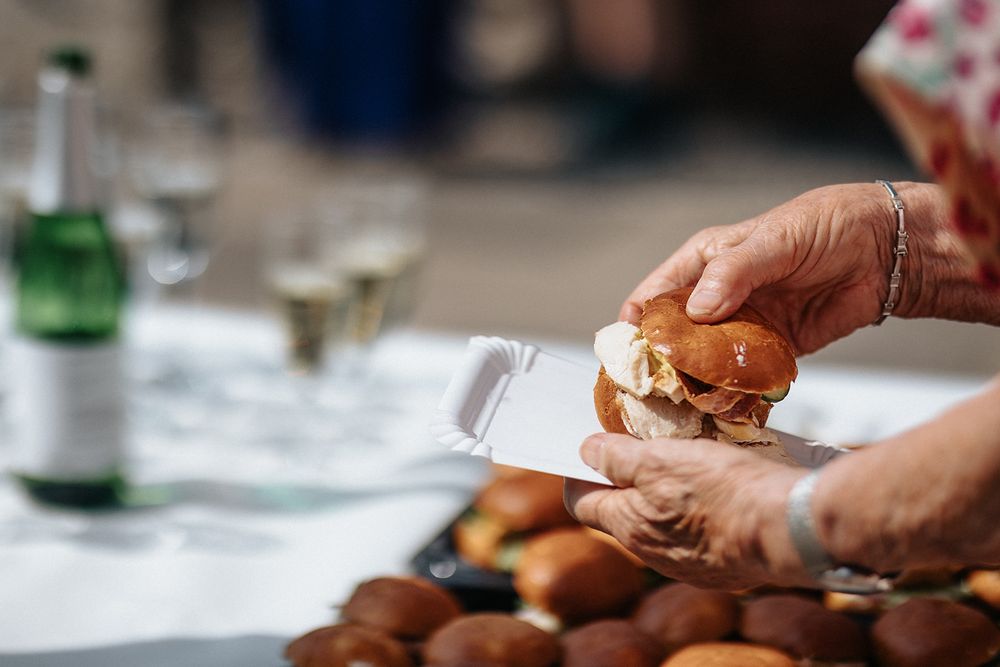 Hands prepare fresh dough by kneading and shaping it on a floured wooden surface in a kitchen.