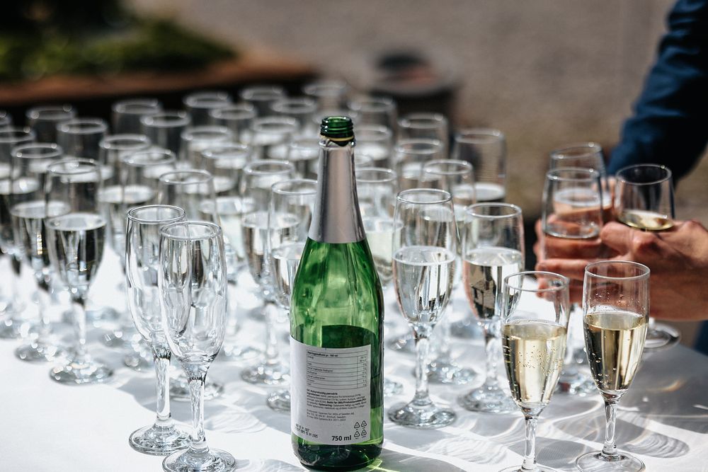 Champagne flutes and wine glasses arranged on a white tablecloth with an open bottle for a celebratory event.