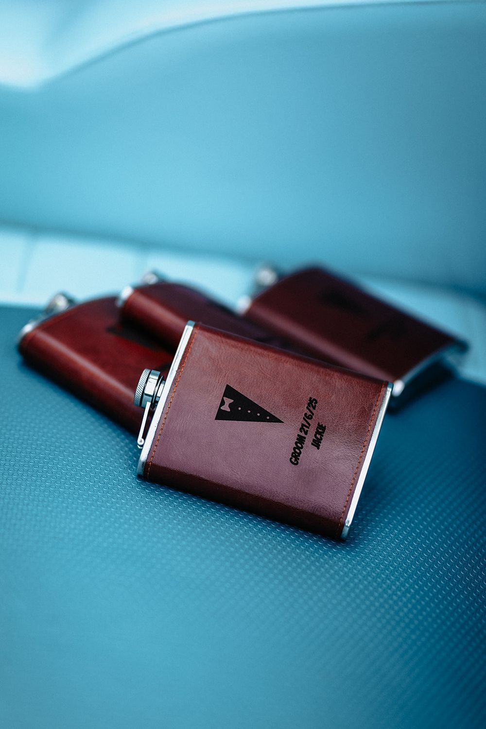 Several burgundy leather wallets arranged in a row against a blue textured background.