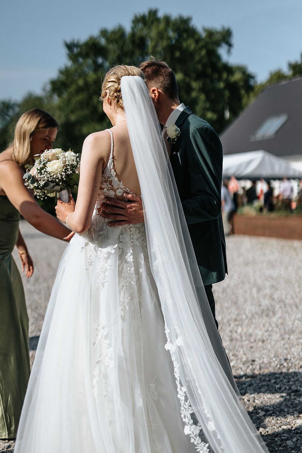 Series of candid moments showing bride in flowing white gown with lace details and long veil during outdoor wedding.