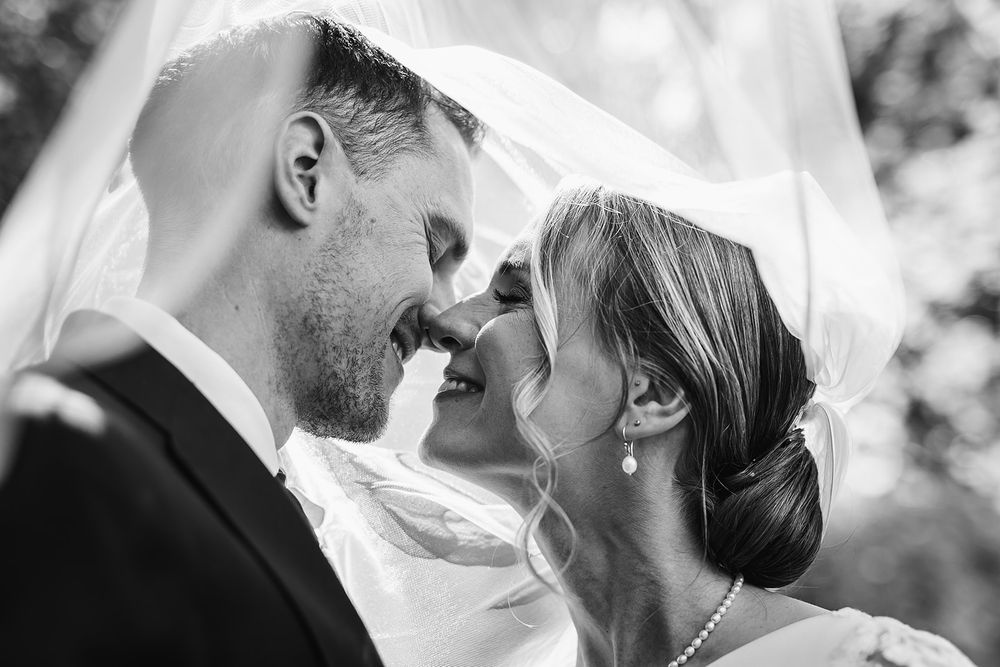 A romantic black and white photo collage showing close-up moments of a couple sharing tender kisses at their wedding.