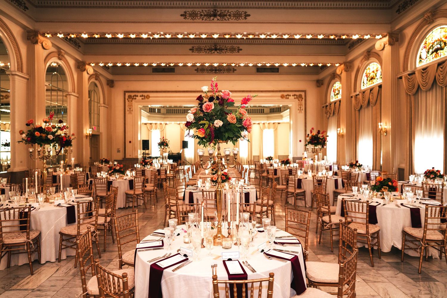 Grand ballroom decorated with elegant chandeliers and round tables for a formal wedding reception Columbus Ohio Wedding Venues