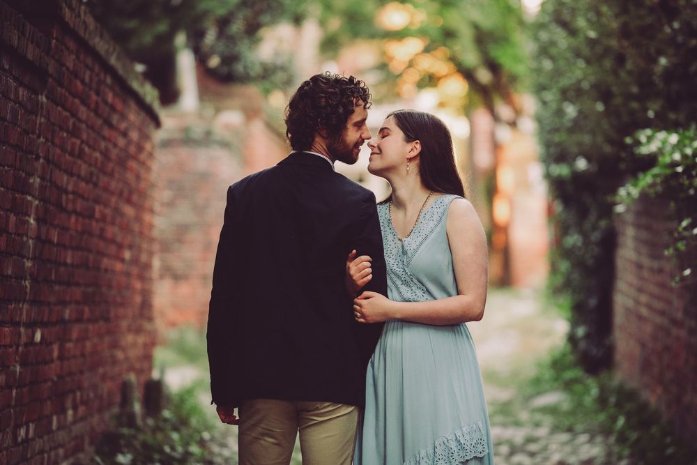 Golden sunrise light casting a romantic glow on couple during their Alexandria Waterfront engagement session