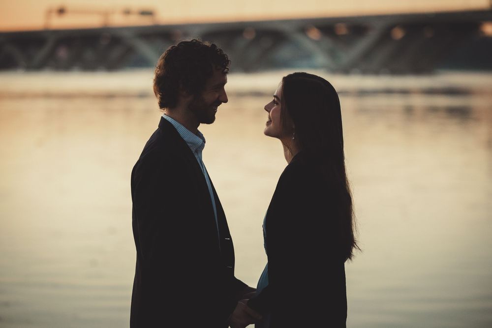 Timeless film-style engagement photos featuring the Potomac River and historic Alexandria skyline