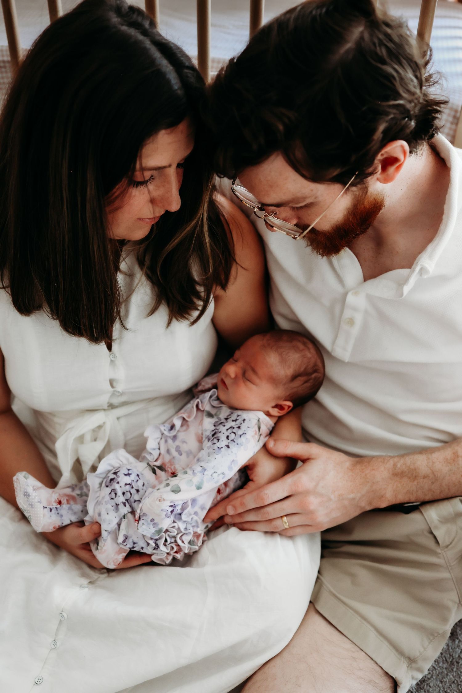 Intimate maternity photo series showing couple in white clothing embracing and sharing tender moments together.