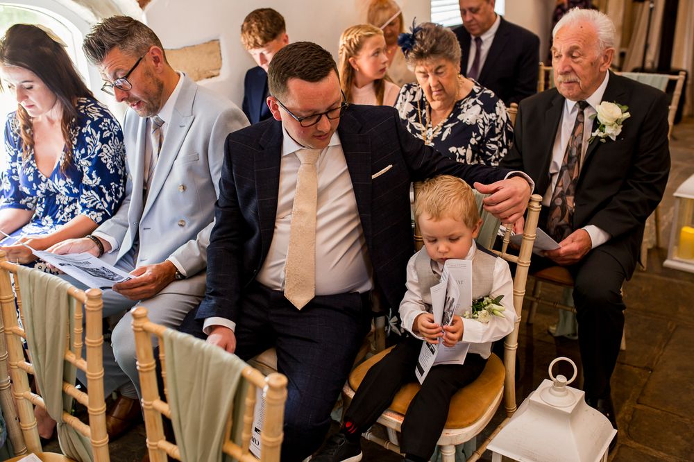 Wedding ceremony seating arrangement with guests in formal attire.