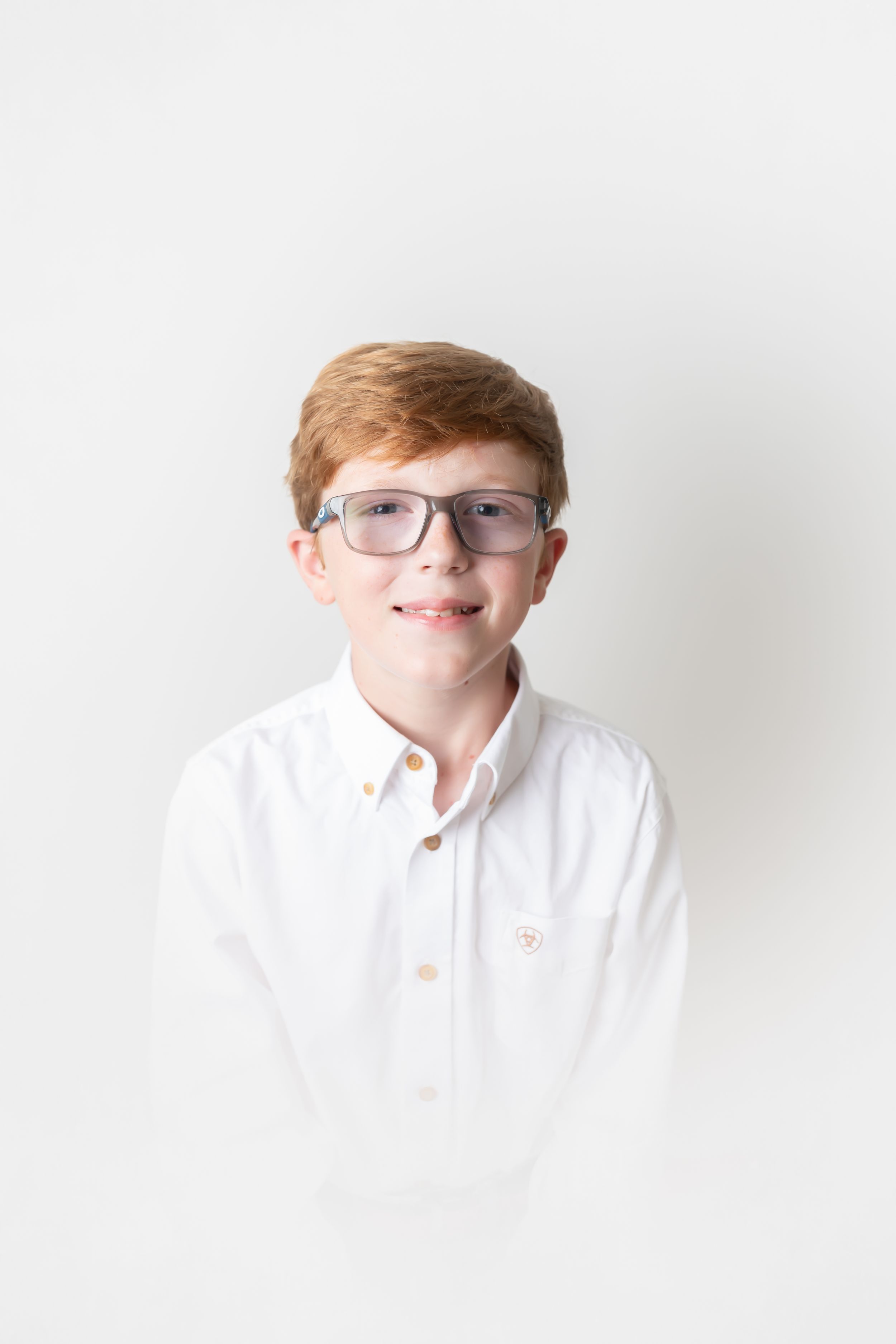 Portrait series of a person in glasses and white shirt against light background.
