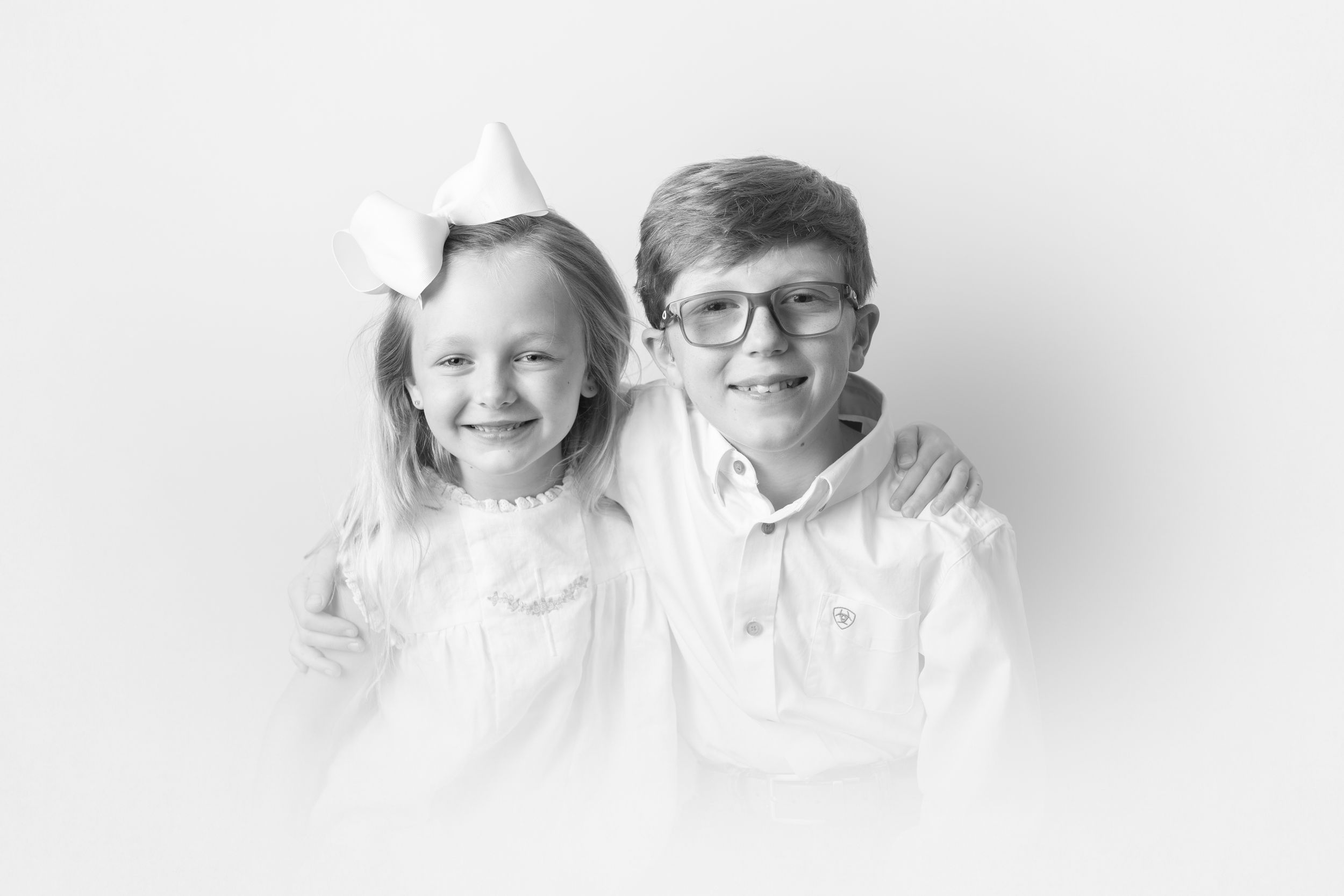 Minimalist white studio portraits showing two people together.