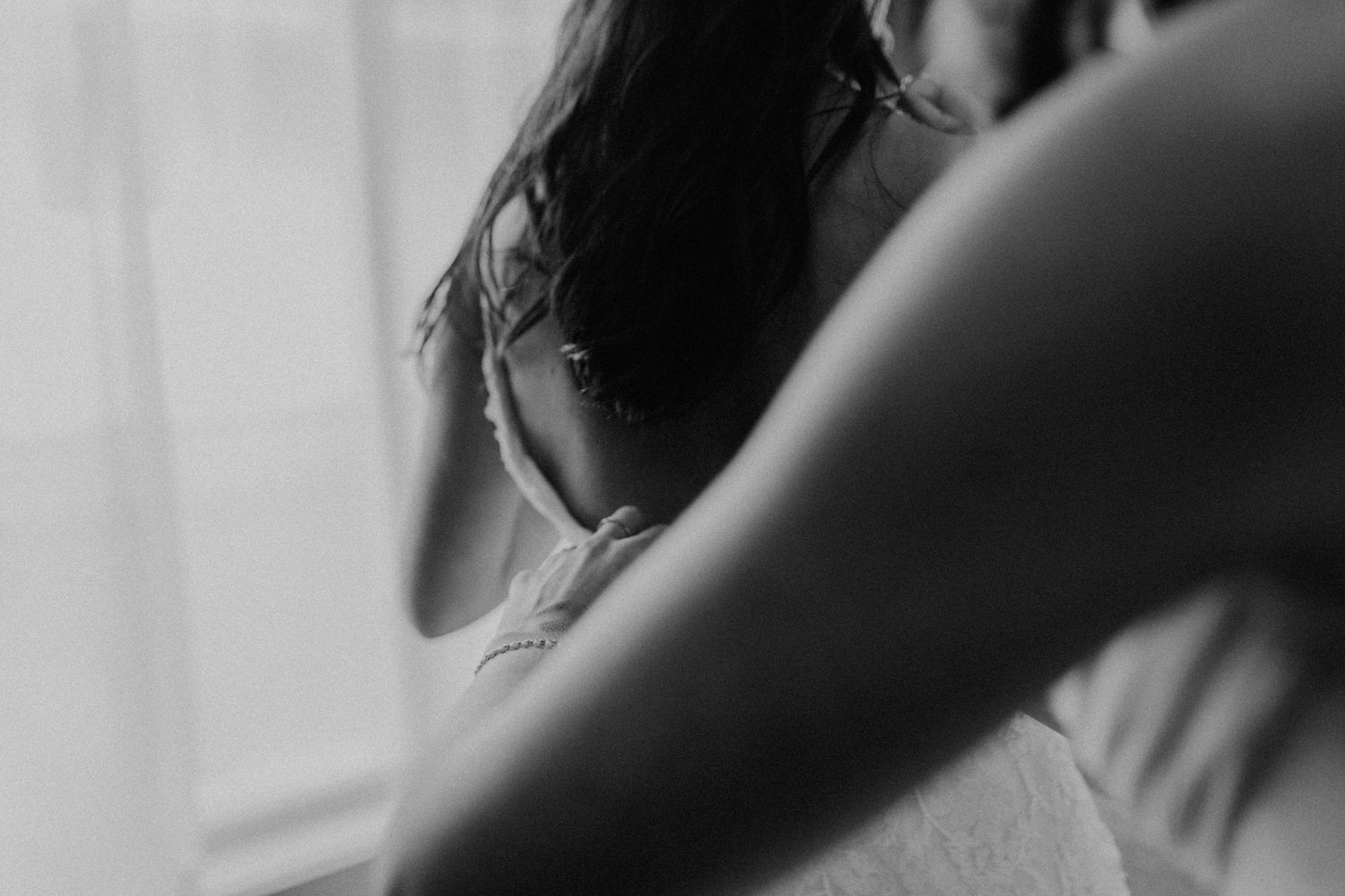 A black and white portrait photograph showing a person's face in a soft, ethereal lighting style.