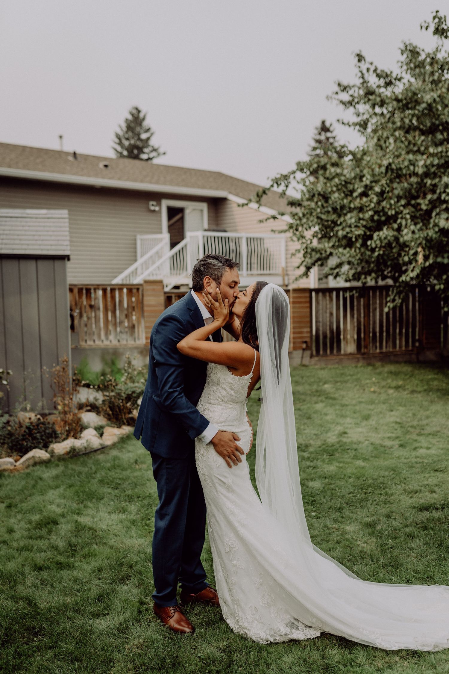 A romantic first look moment between newlyweds in a backyard garden setting with a flowing white wedding dress.