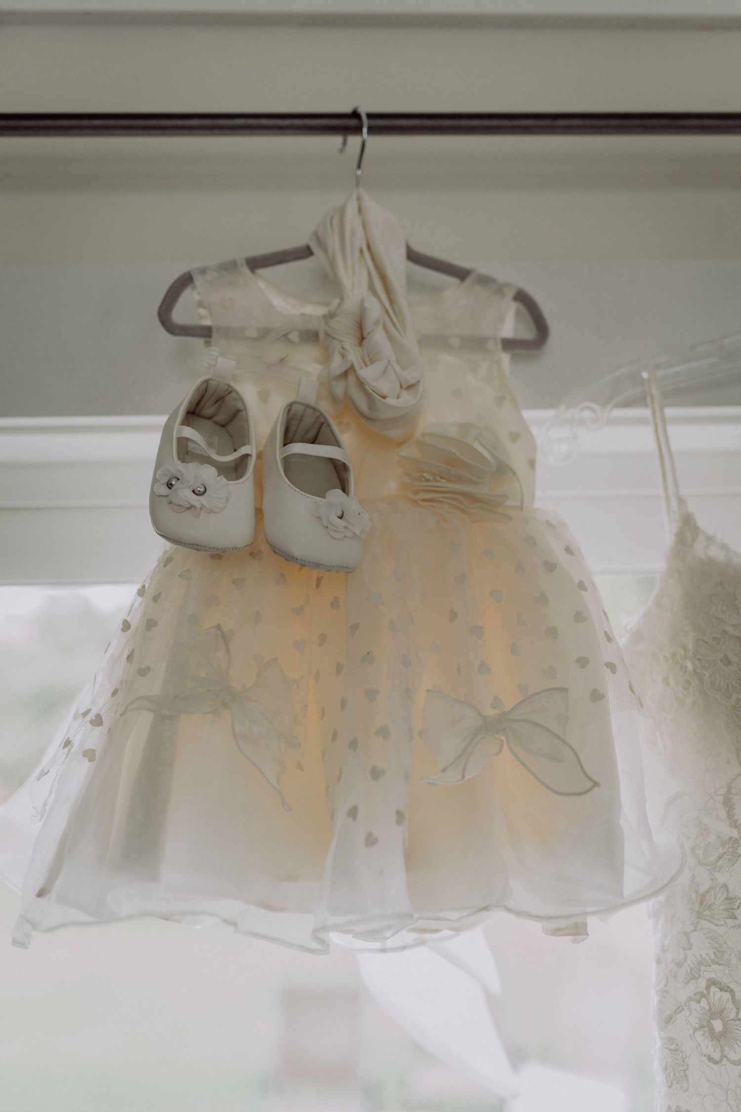 Delicate white sheer curtains hanging on a rod create a soft, ethereal window treatment with a subtle peachy glow.