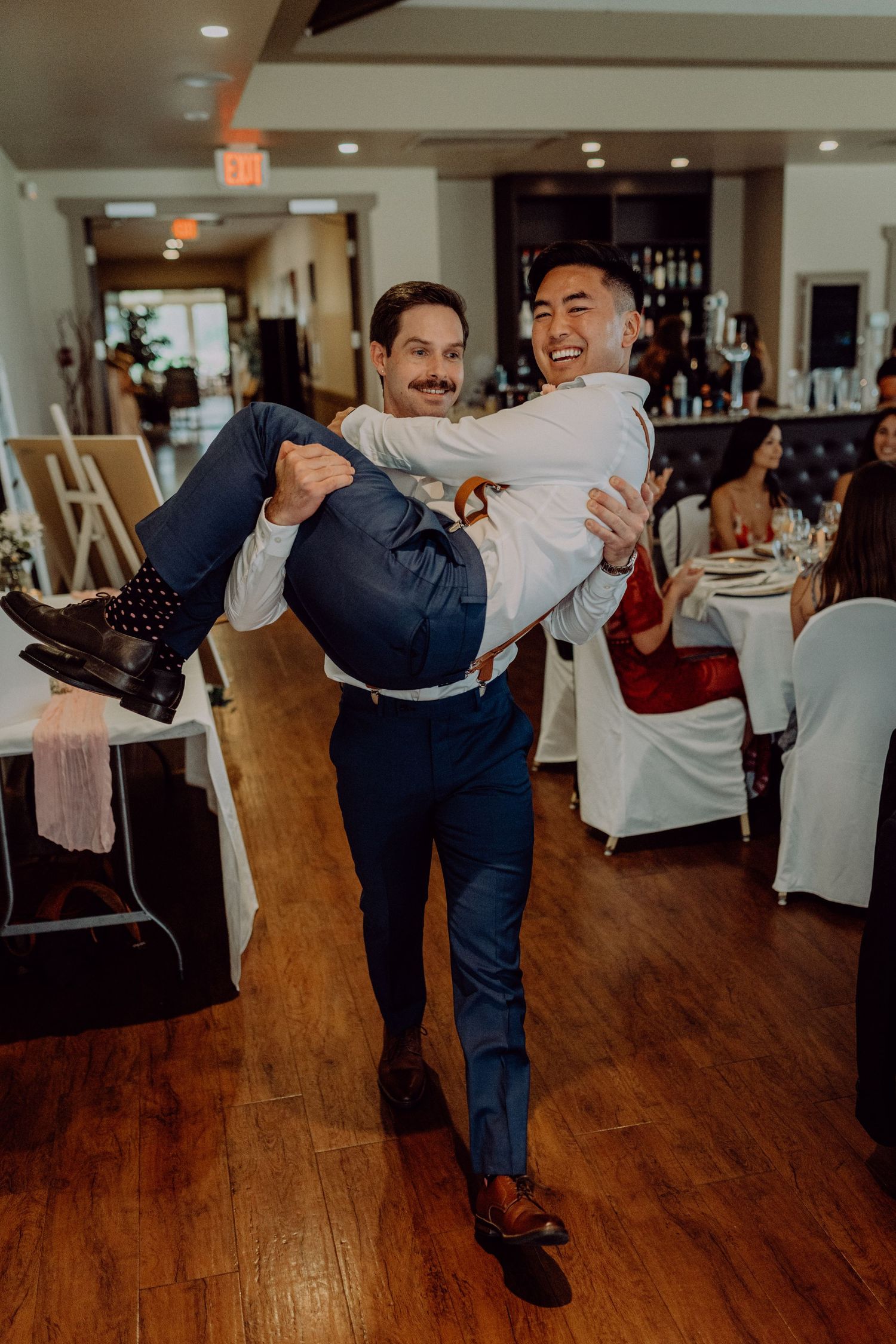 Four sequential photos show joyful dance partners practicing a swing dance lift move on a wooden dance floor.