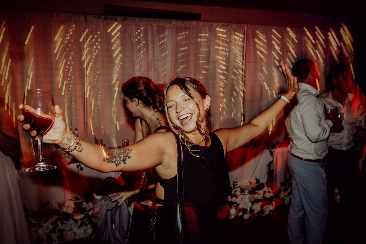 A dance party scene with people dancing under warm lighting and decorative string lights.