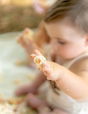 Close-up shot of messy cake smashing during a first birthday celebration.