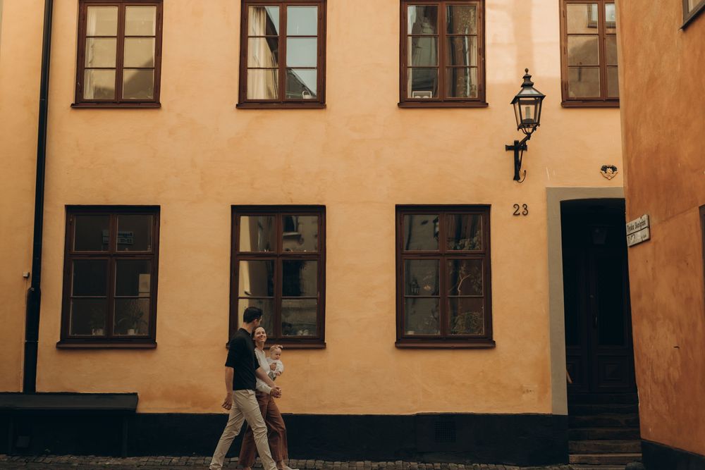 family with a baby walking streets in Gamla Stan during vacation photoshoot for families travelling to Stockholm