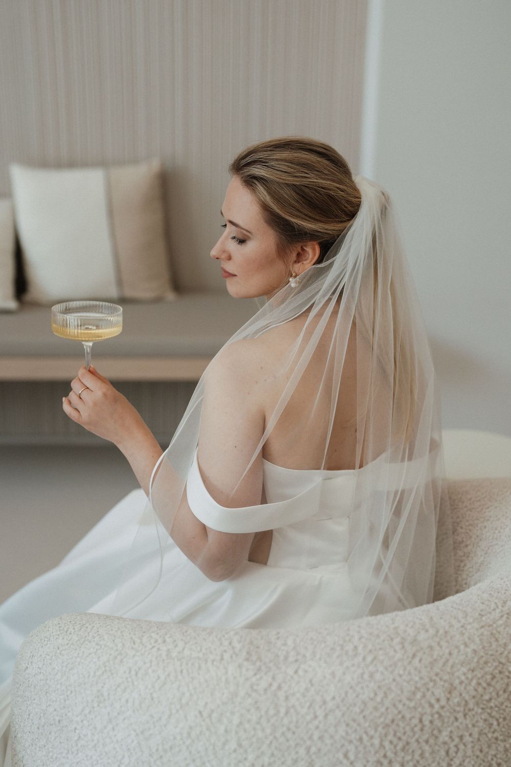 Braut hält ein Champagner Glas.
