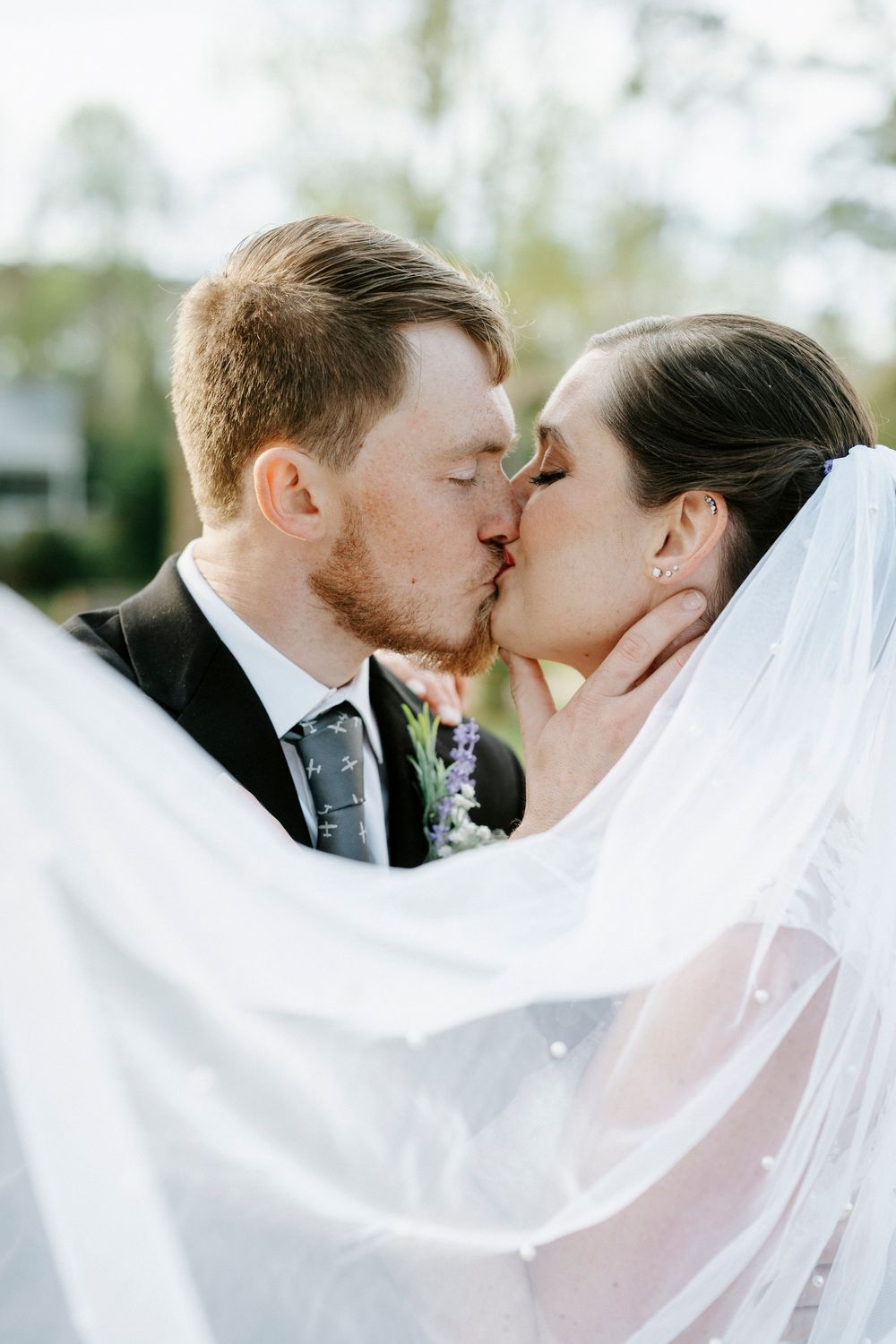 A romantic wedding kiss sequence with flowing white veil captured in three progressive frames.