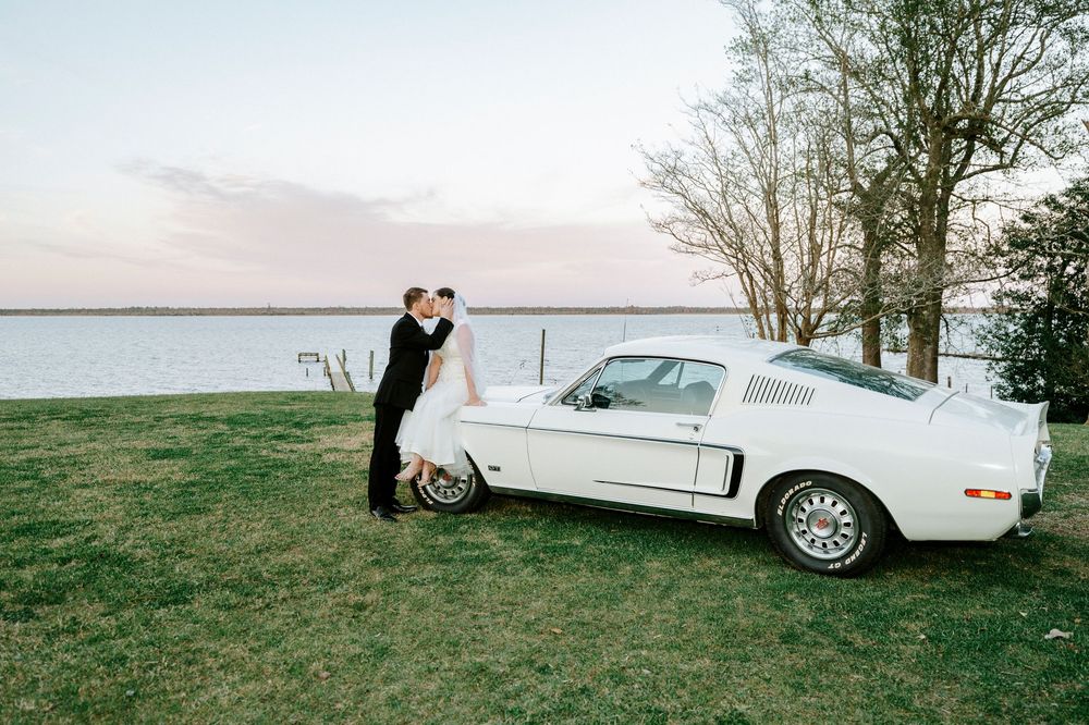 A classic white Ford Thunderbird parked in a scenic outdoor setting during a romantic photoshoot.