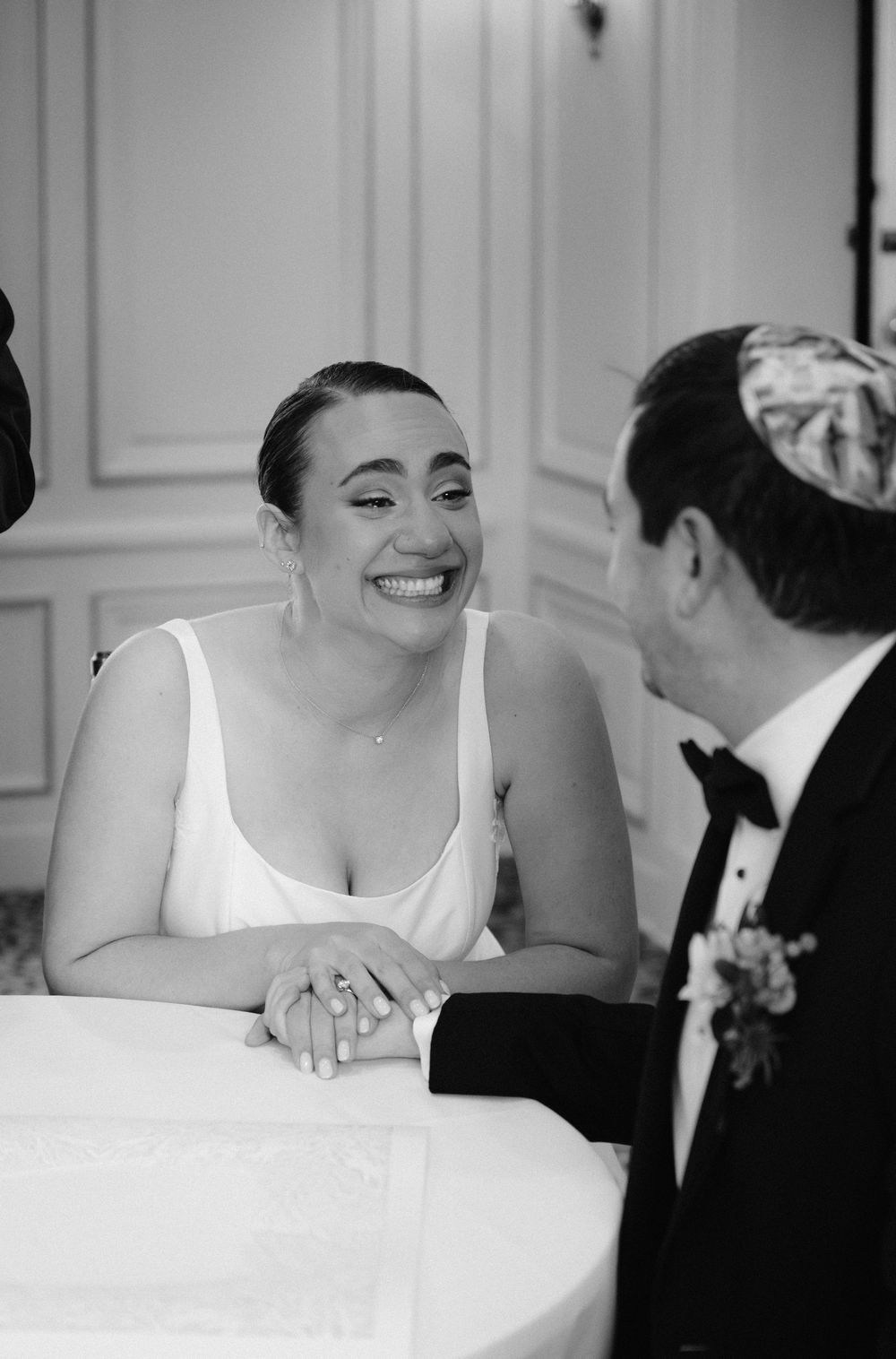 Black and white wedding photo sequence showing candid moments between a couple at a table.