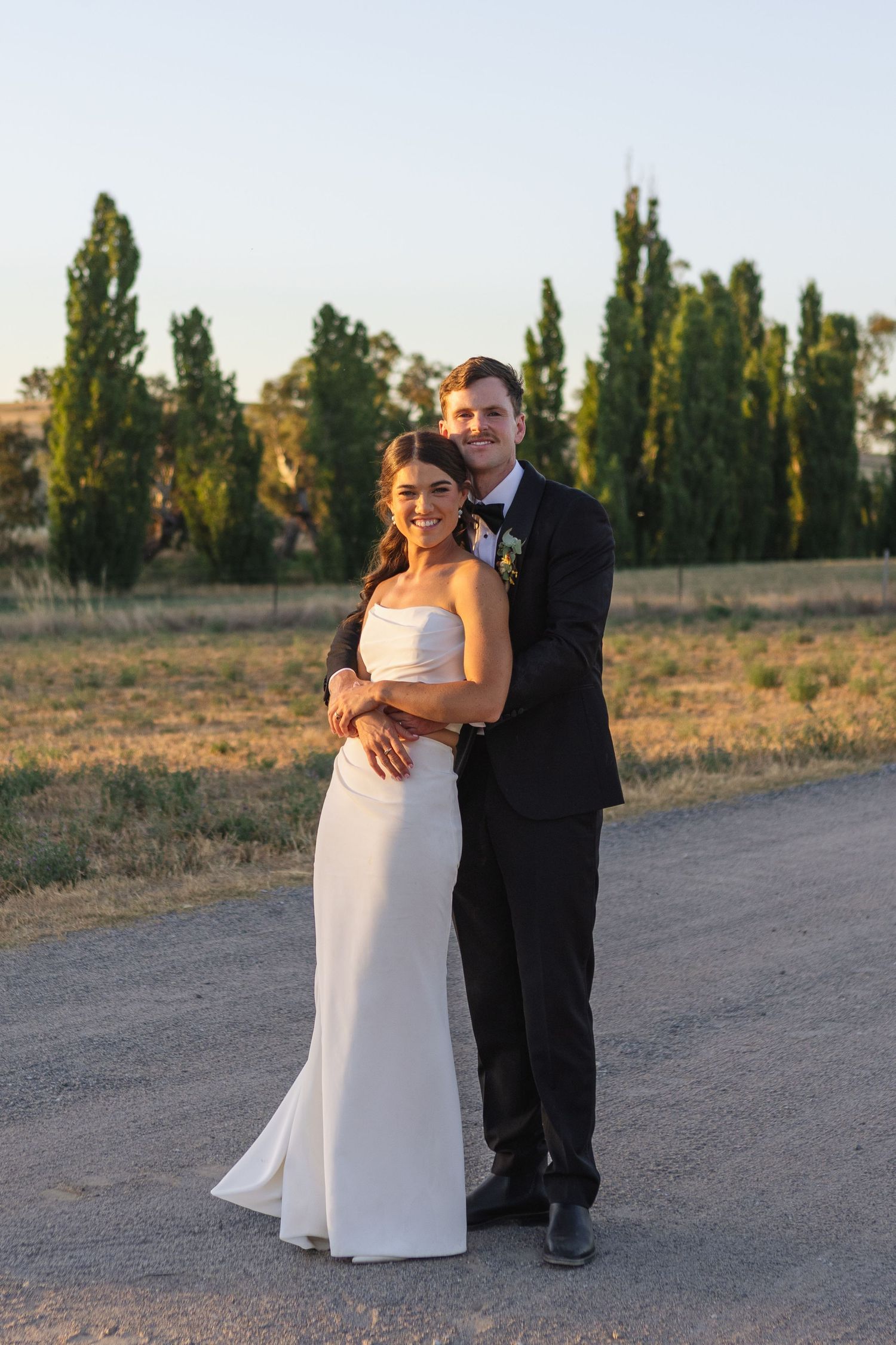 Bride and groom hugging from behind at NSW Country wedding