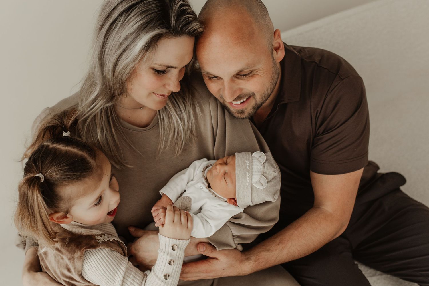 gezin met newborn baby samen op bed tijdens fotoshoot in studio Soest
