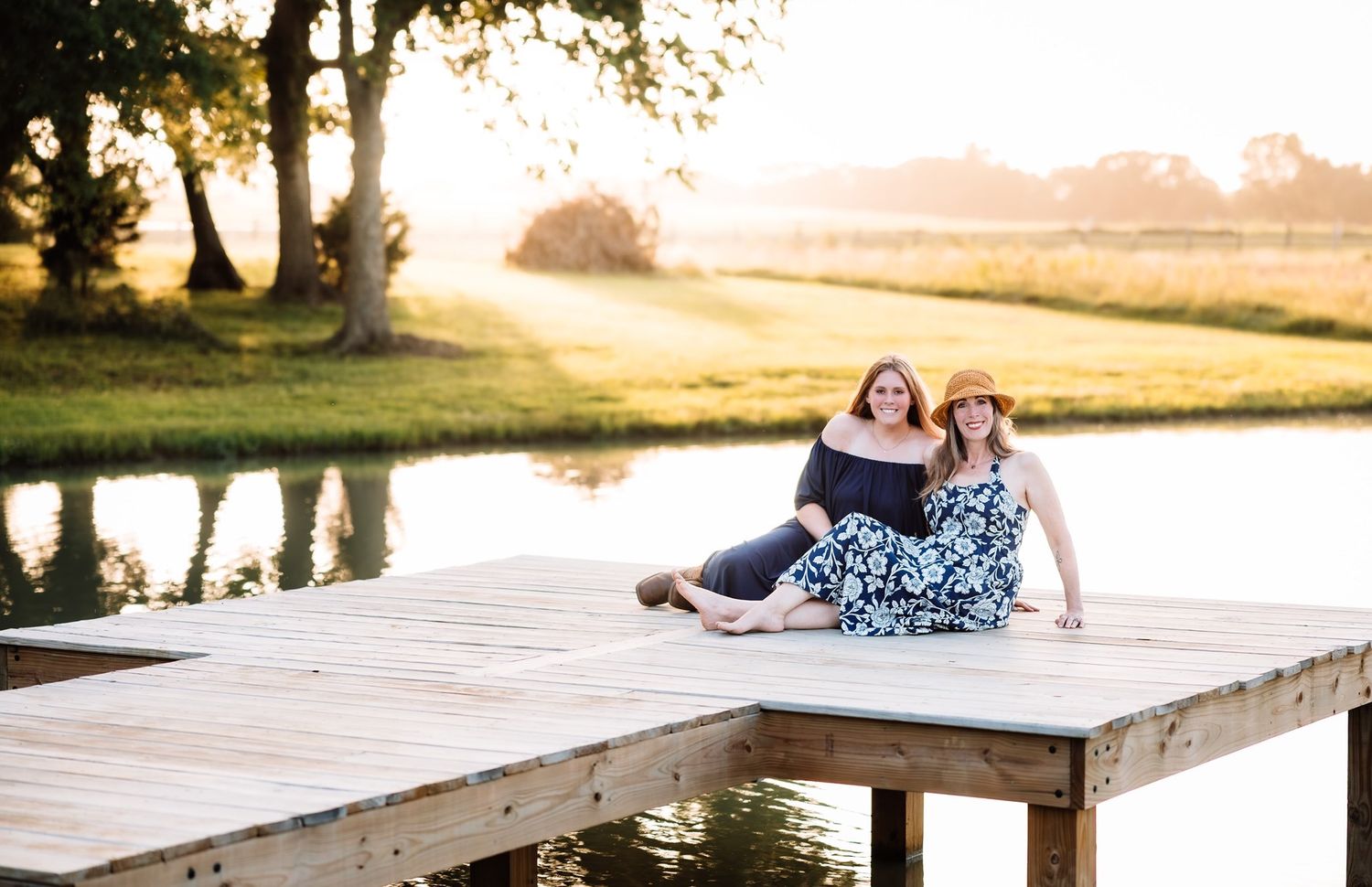 Mother daughter sitting on dock with photographer located throughout the Kansas City Metro area. Based in Blue Springs, Missouri.