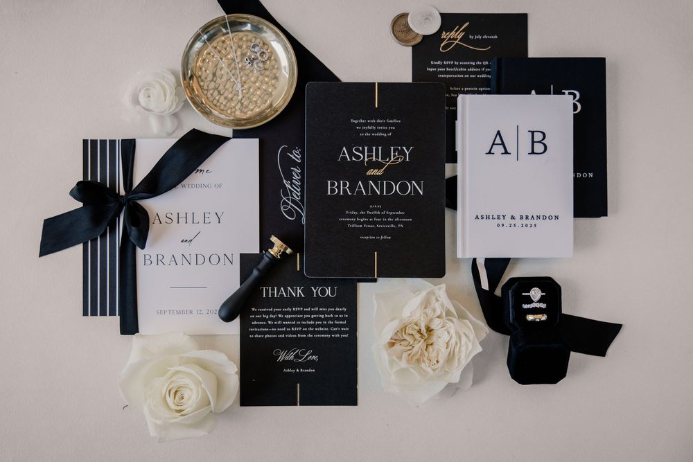 Elegant black and white wedding stationery suite for Ashley and Brandon with invitations, thank you cards, and white roses.