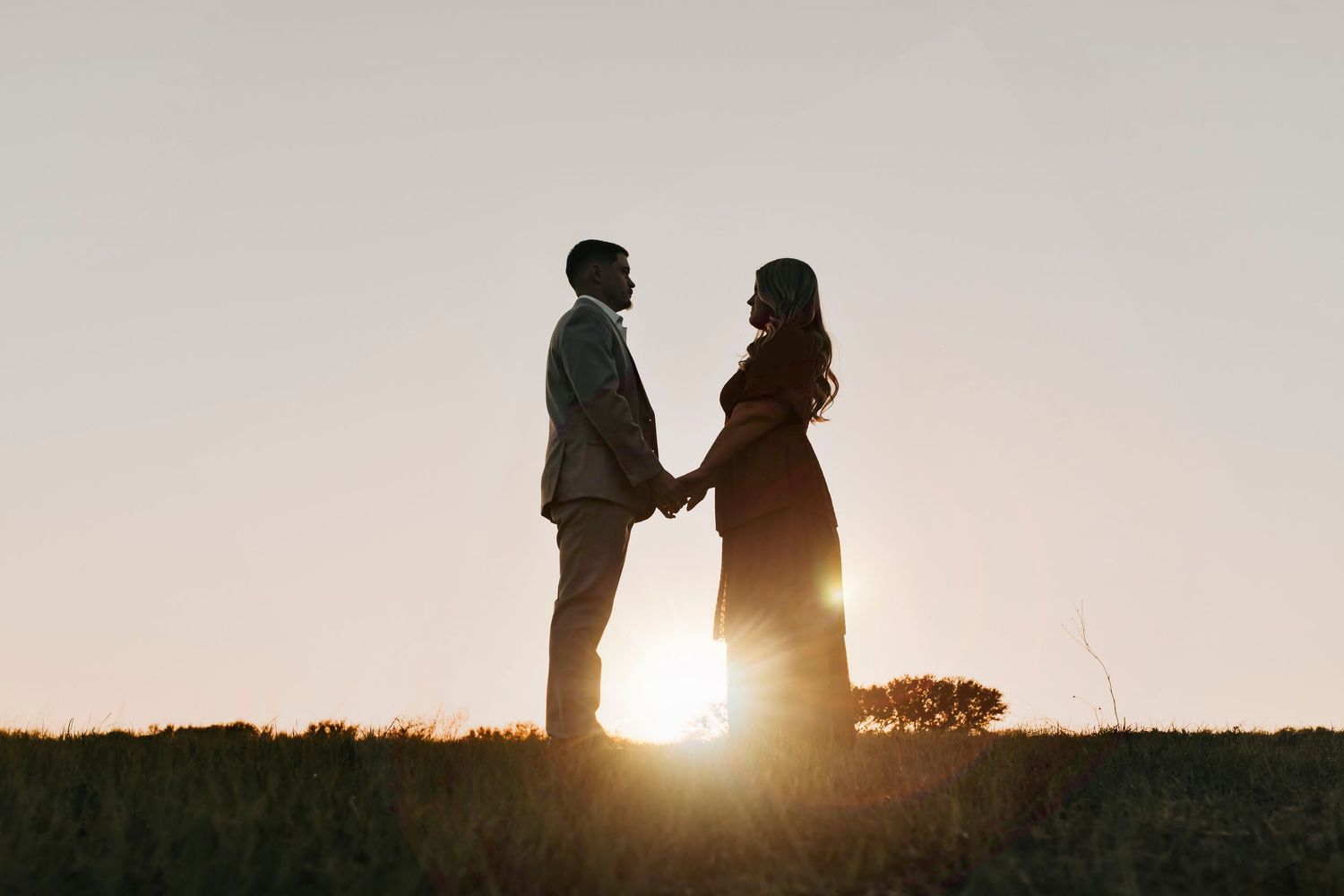 Engaged couple laughing together in a scenic field at Murrell Park engagement session.