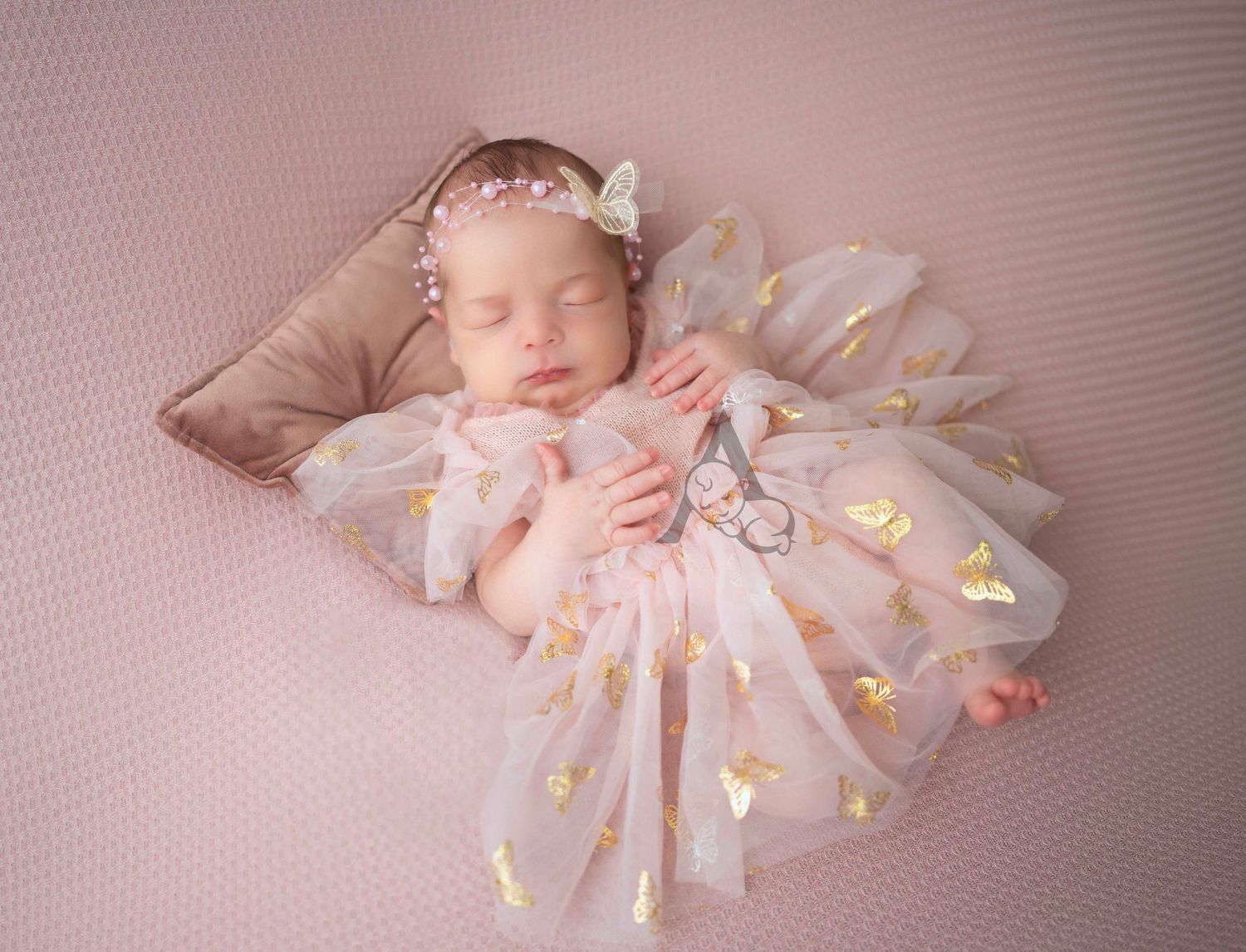 Newborn baby wearing a pink tulle dress lies on soft pink bedding in a dreamy studio portrait at The Affinity Studio in St Augustine