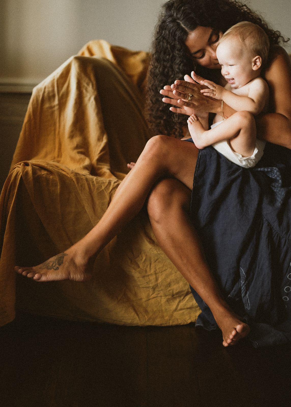 A series of intimate lifestyle photos showing tender moments between parent and child on a brown couch in warm lighting.
