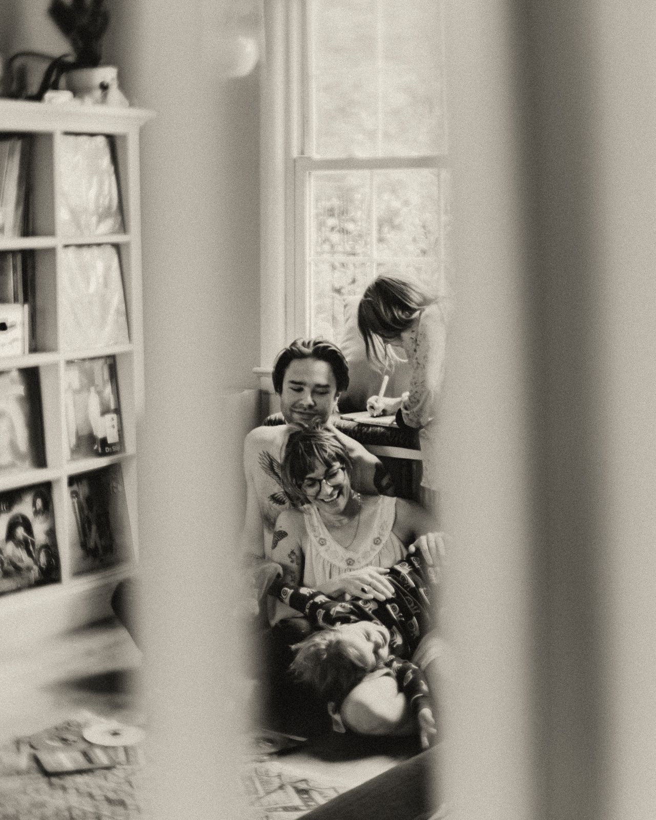 A series of black and white photographs showing someone reading in a cozy window nook with bookshelves nearby.