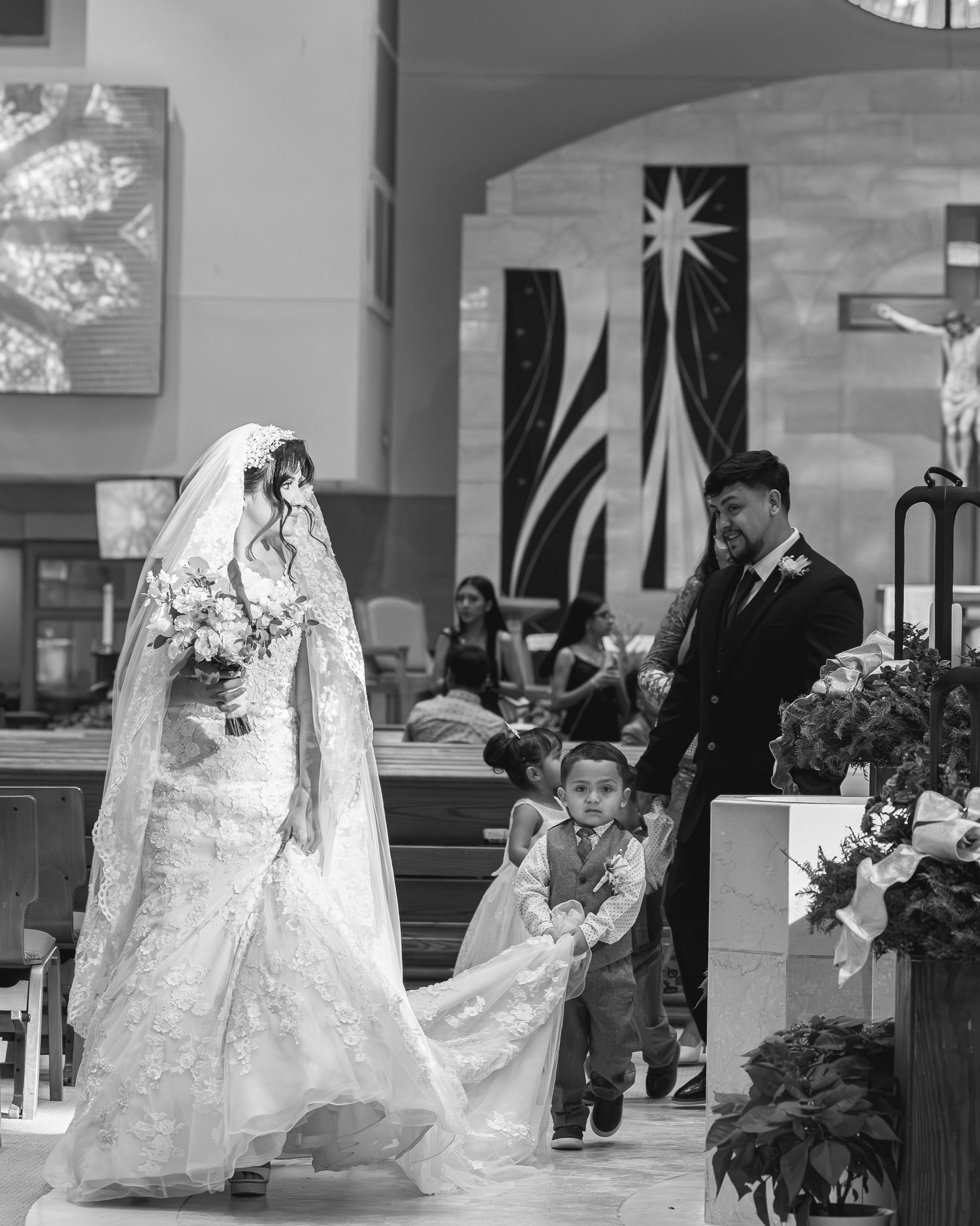 Black and white wedding photos showing ceremony moments in a church with artistic composition.