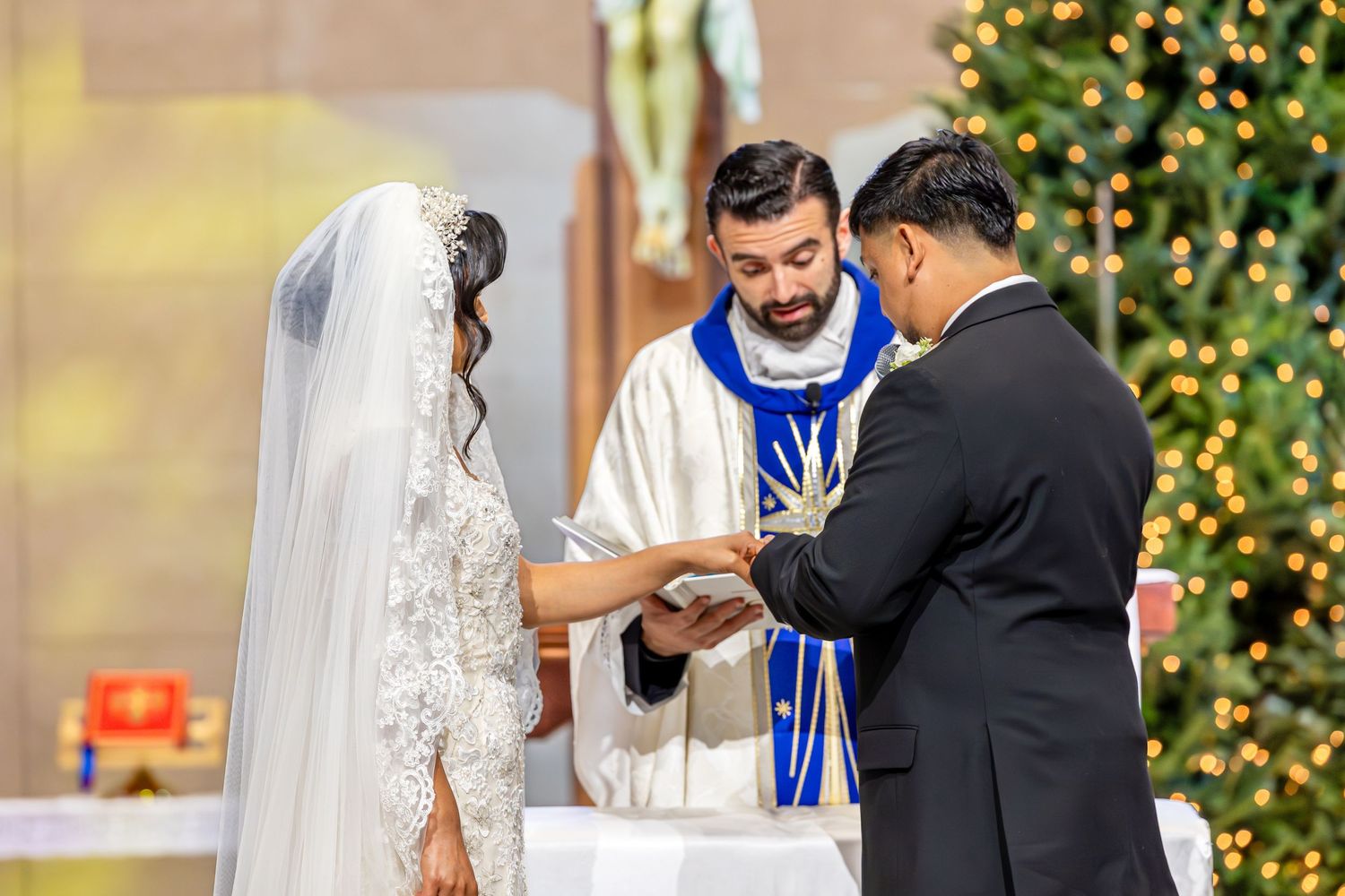 A traditional church wedding ceremony with a Christmas tree glowing in the background.