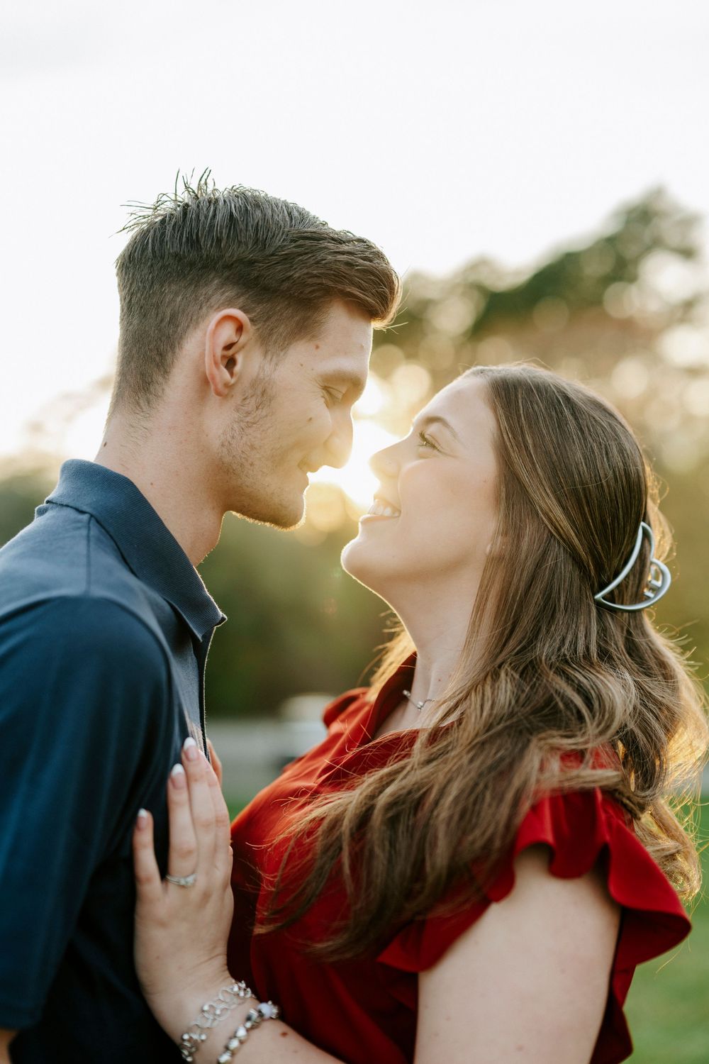 A romantic couple embraces during a sunset photoshoot outdoors.
