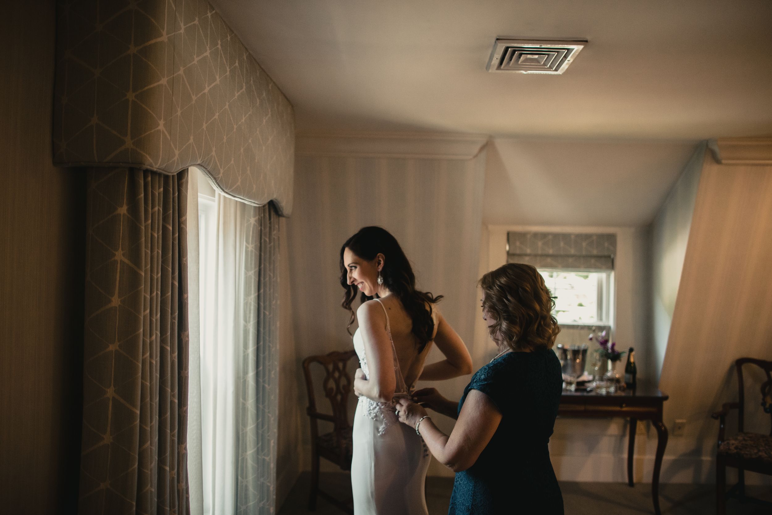 Couple sharing an intimate moment in a dimly lit indoor setting with elegant curtains and decor.