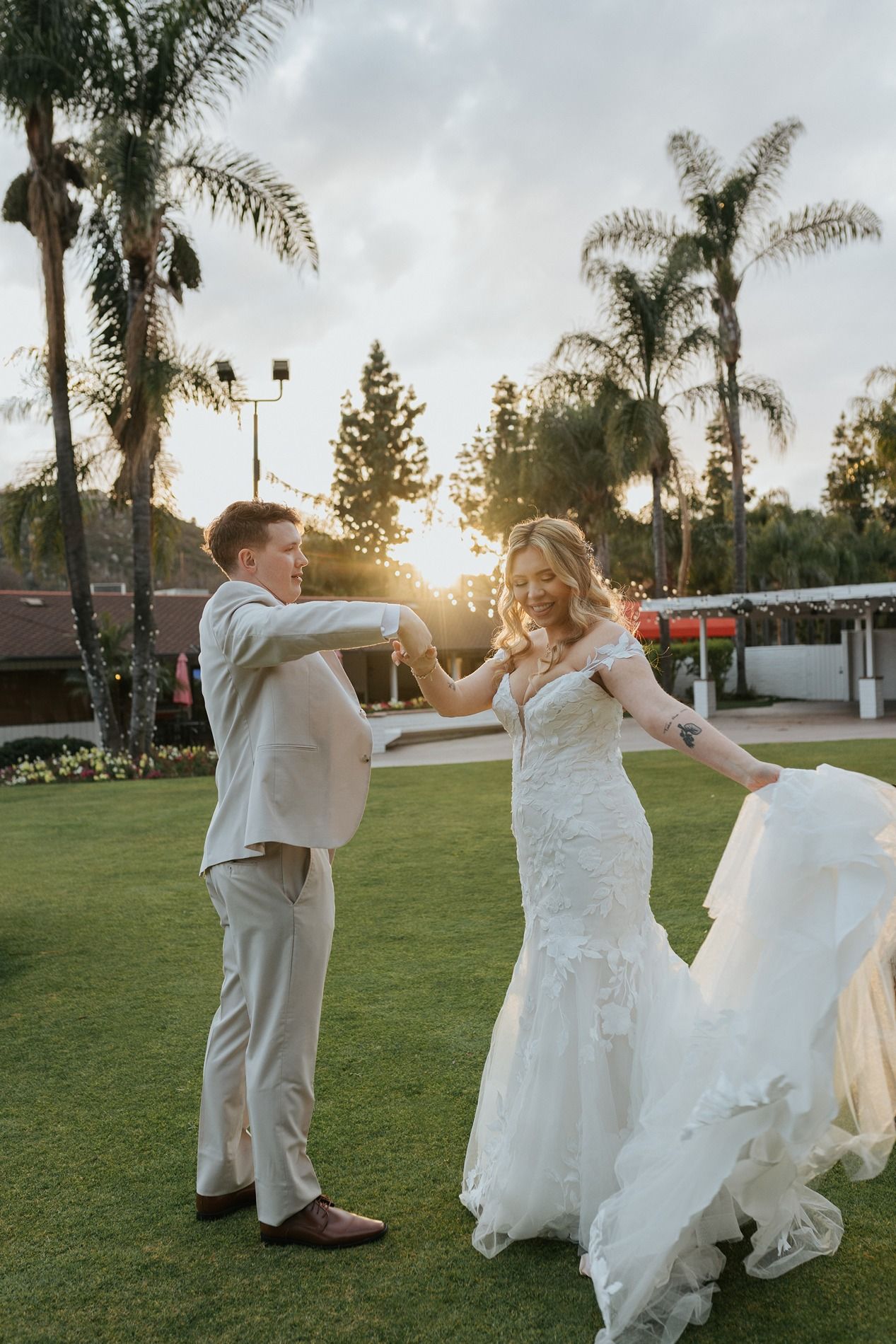 A romantic wedding moment captured outdoors with a beautiful bouquet of pink and white roses at sunset.