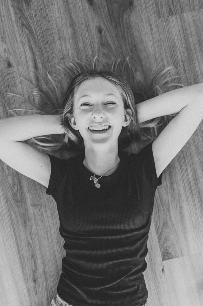 Black and white photos showing joyful moments lying on hardwood flooring.
