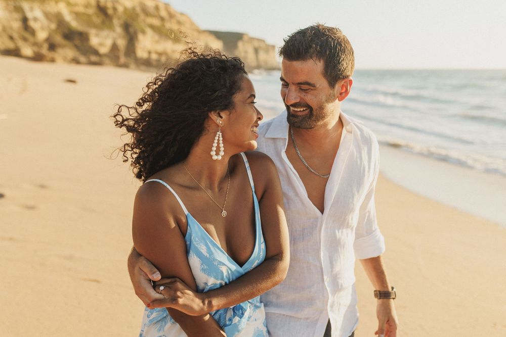 Romantic close up of couple smiling at each other during beach engagement shoot in Portugal