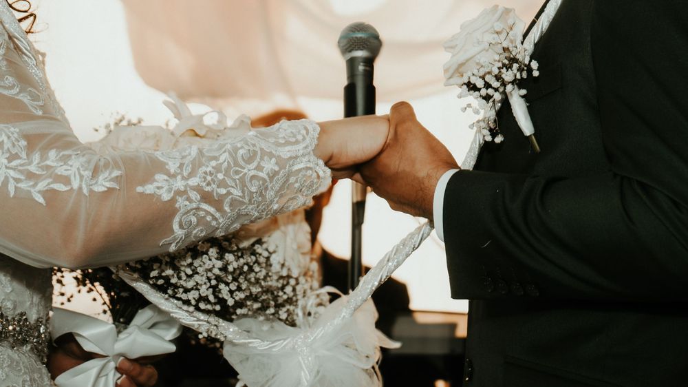 A romantic wedding montage showing close-up details of rings, flowers, and hands during a ceremony.