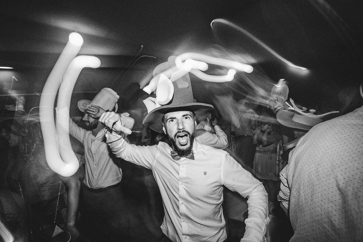 Invitado bailando con sombrero y luces en movimiento durante la fiesta nocturna de una boda en Asturias