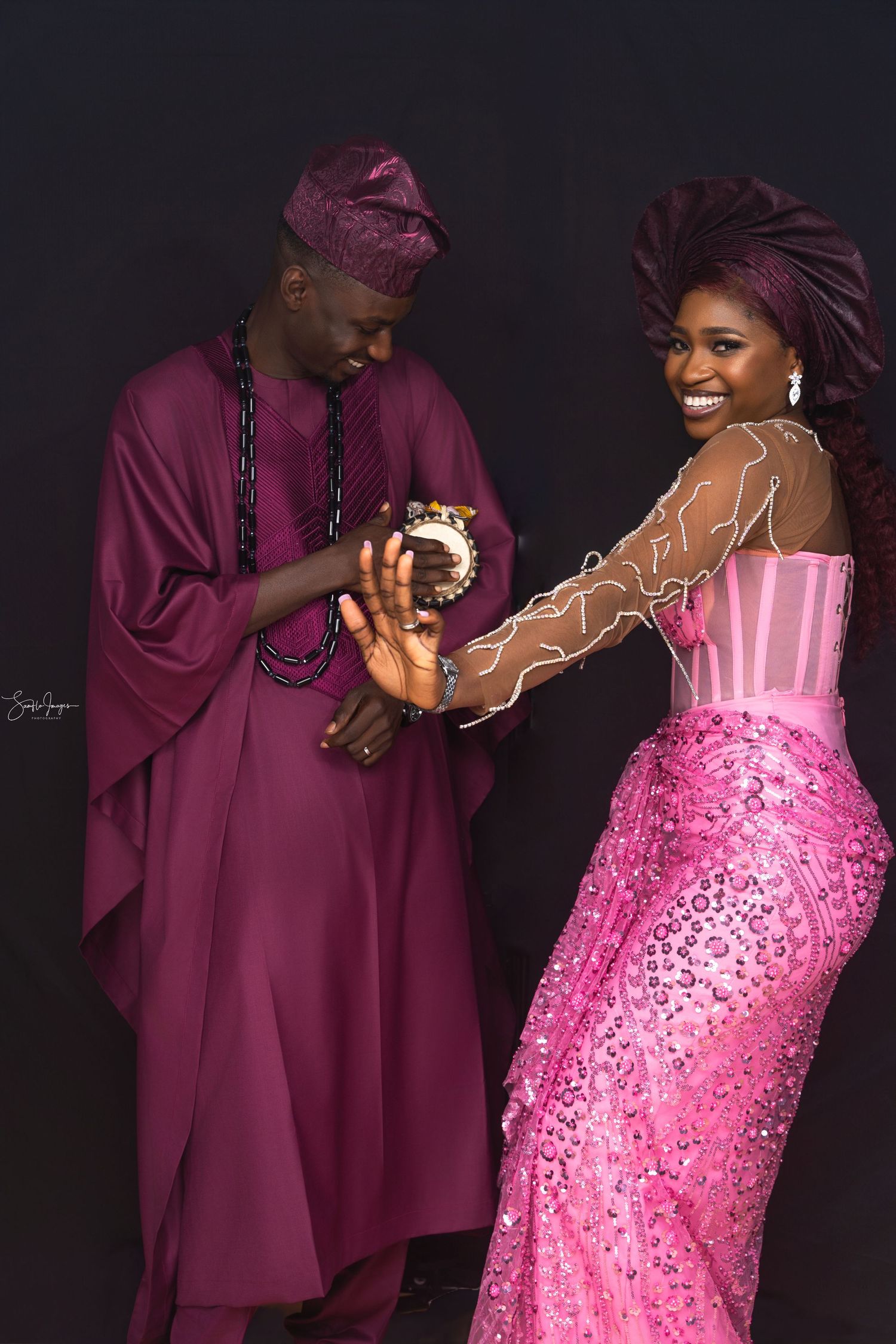 A couple in burgundy agbada and pink sequined dress pose together in a romantic photoshoot sequence.