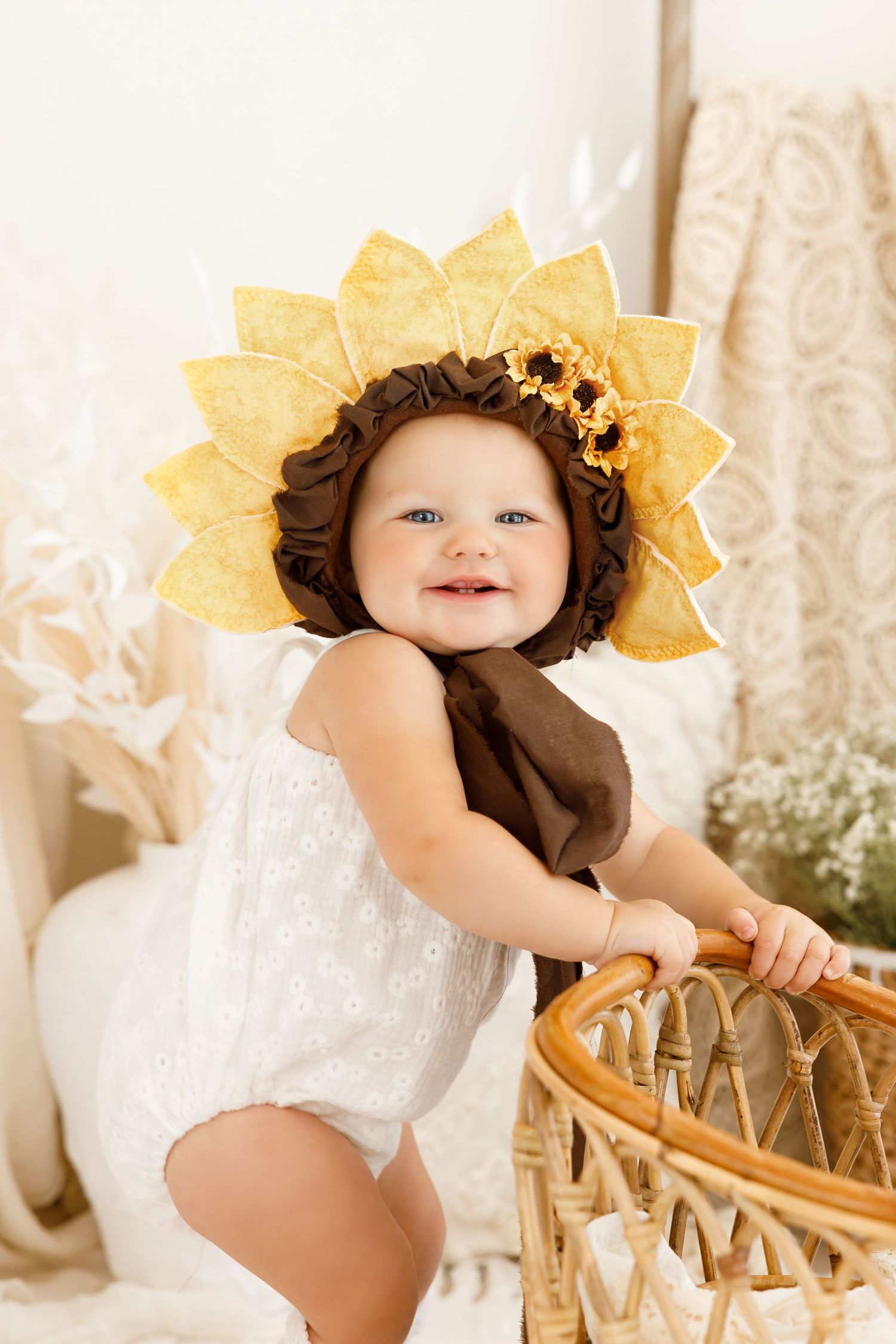 Elegant peach dress photoshoot with gold balloons and garland against white backdrop.